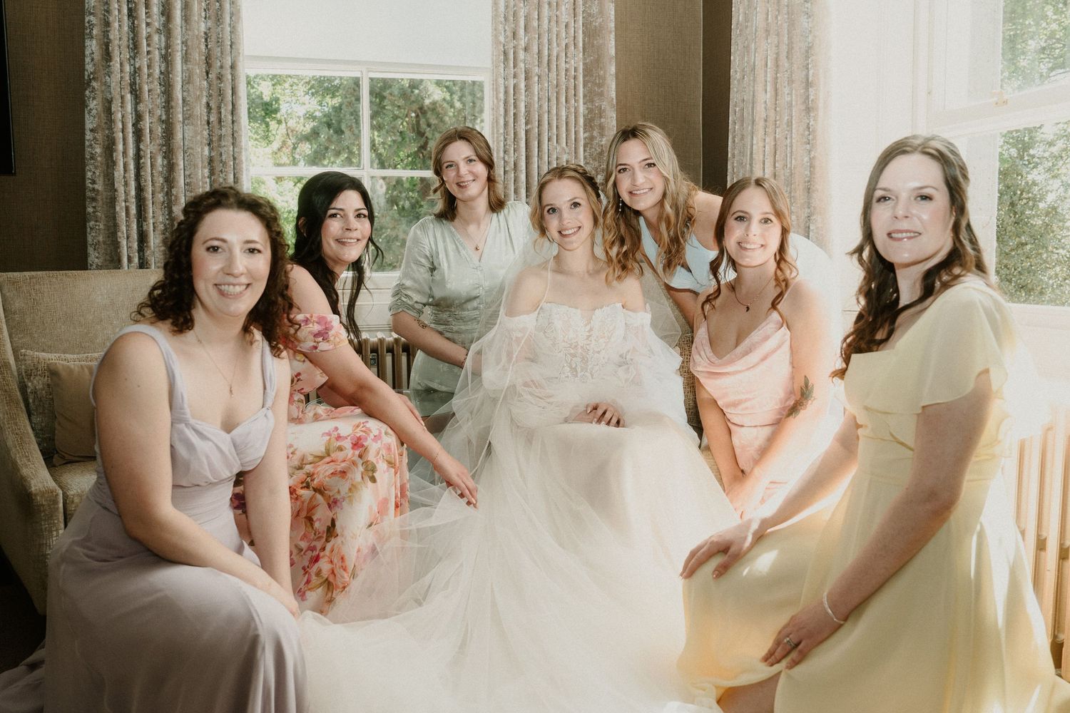 Bridal party getting ready in an elegant room with natural window light.