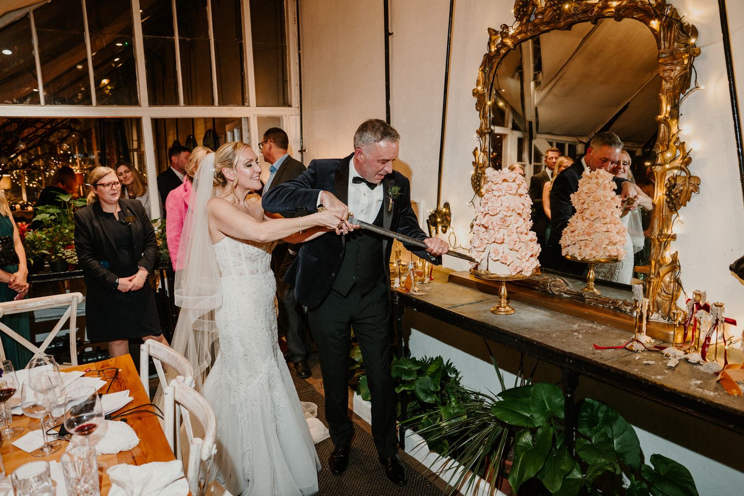 Reception venue features elegant decor with gold-framed mirrors and romantic lighting.