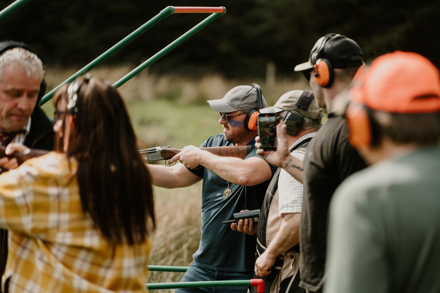 Group learning archery techniques with instructors in an outdoor setting.
