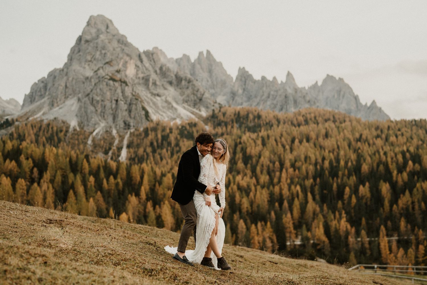 Couple sharing a tender moment in a scenic mountain setting during autumn.