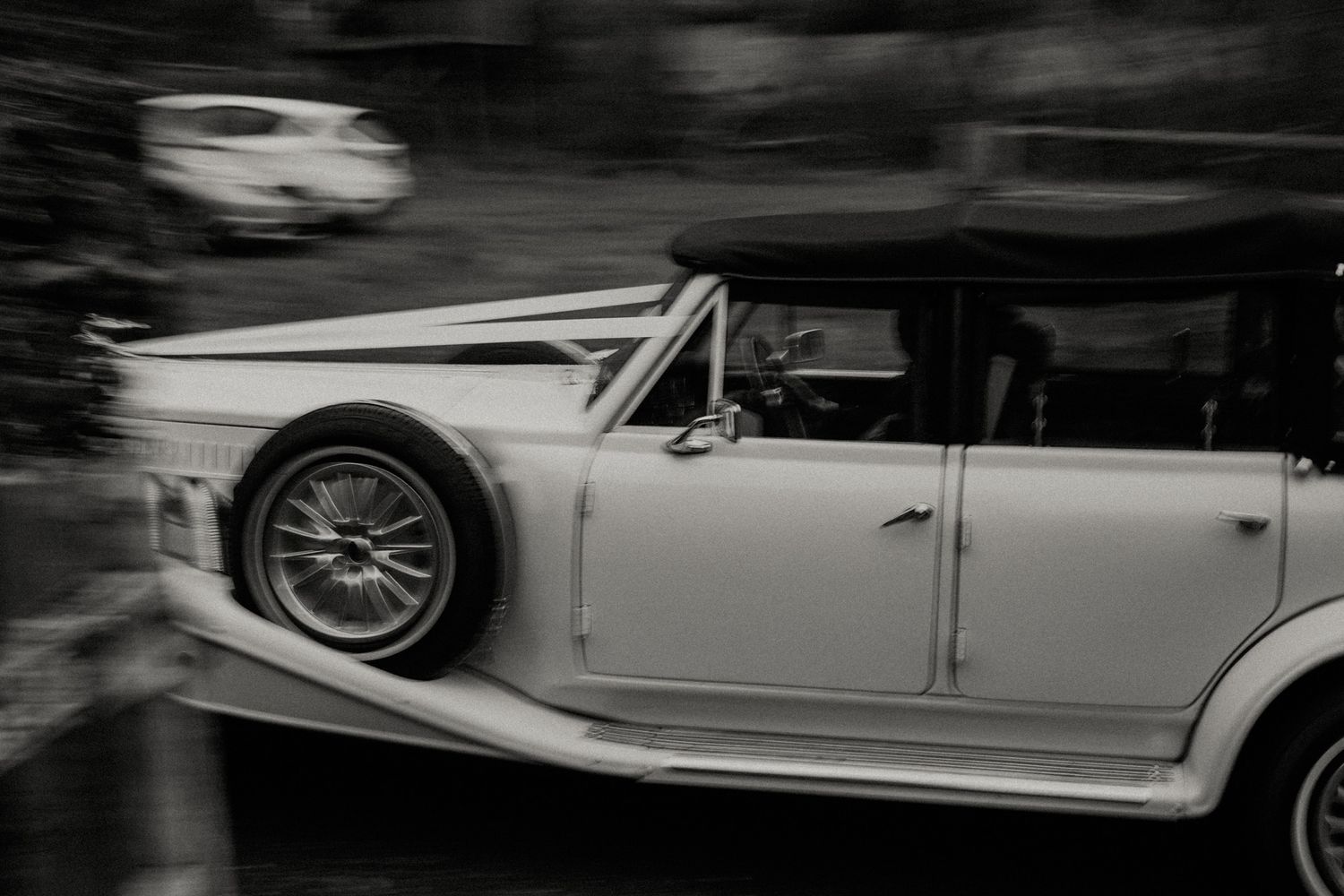 Elegant vintage wedding cars lined up outside a venue.