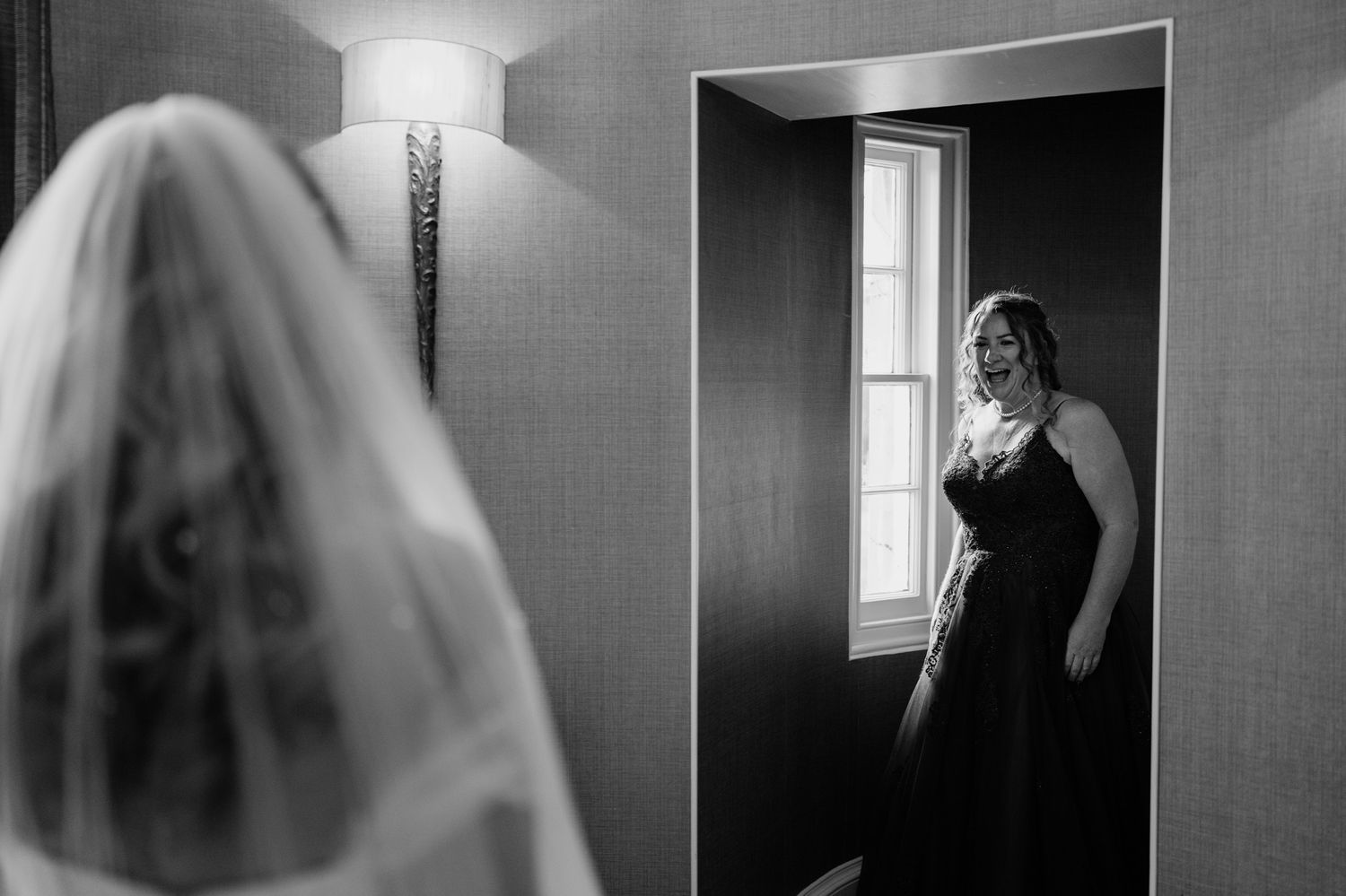 A black and white reflection captured in a mirror during wedding preparations.