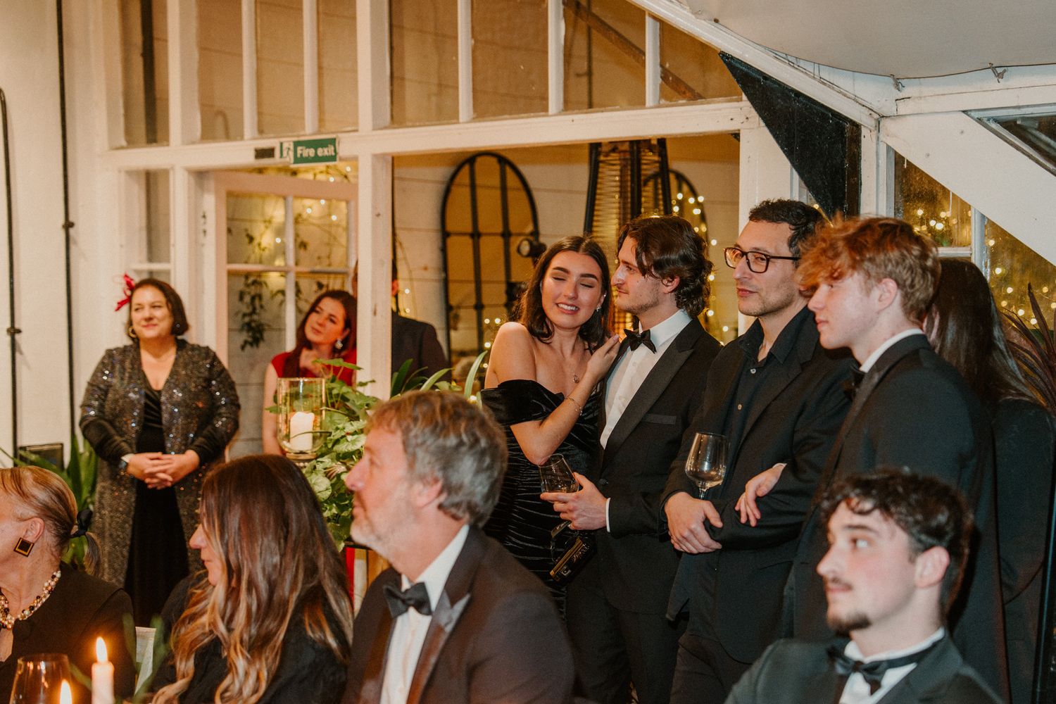 Wedding guests seated at long tables during an intimate indoor reception celebration.