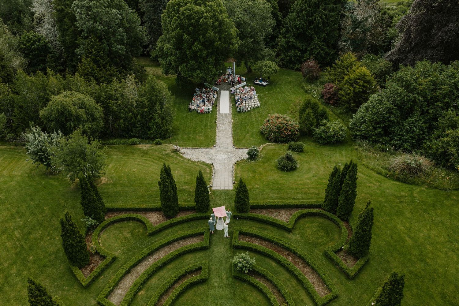 Drone shot showcasing symmetrical garden design with manicured hedges and walking paths.