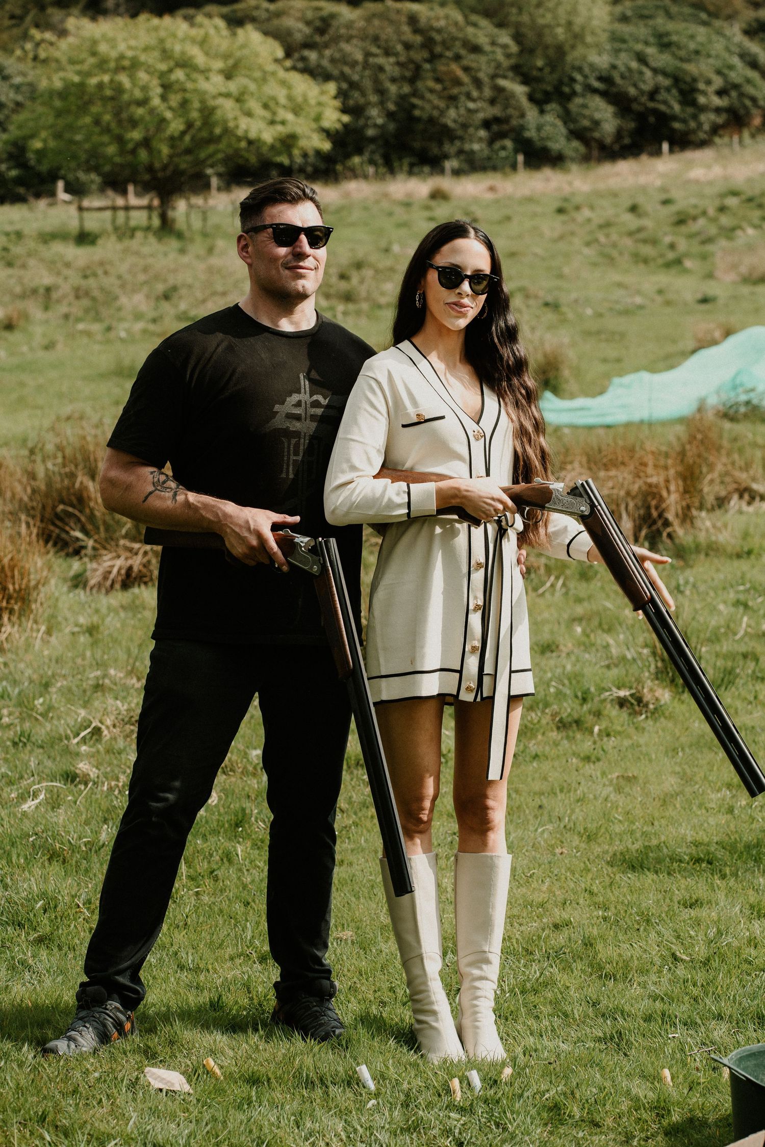 Wedding guests practicing archery on a grassy field during outdoor activities.