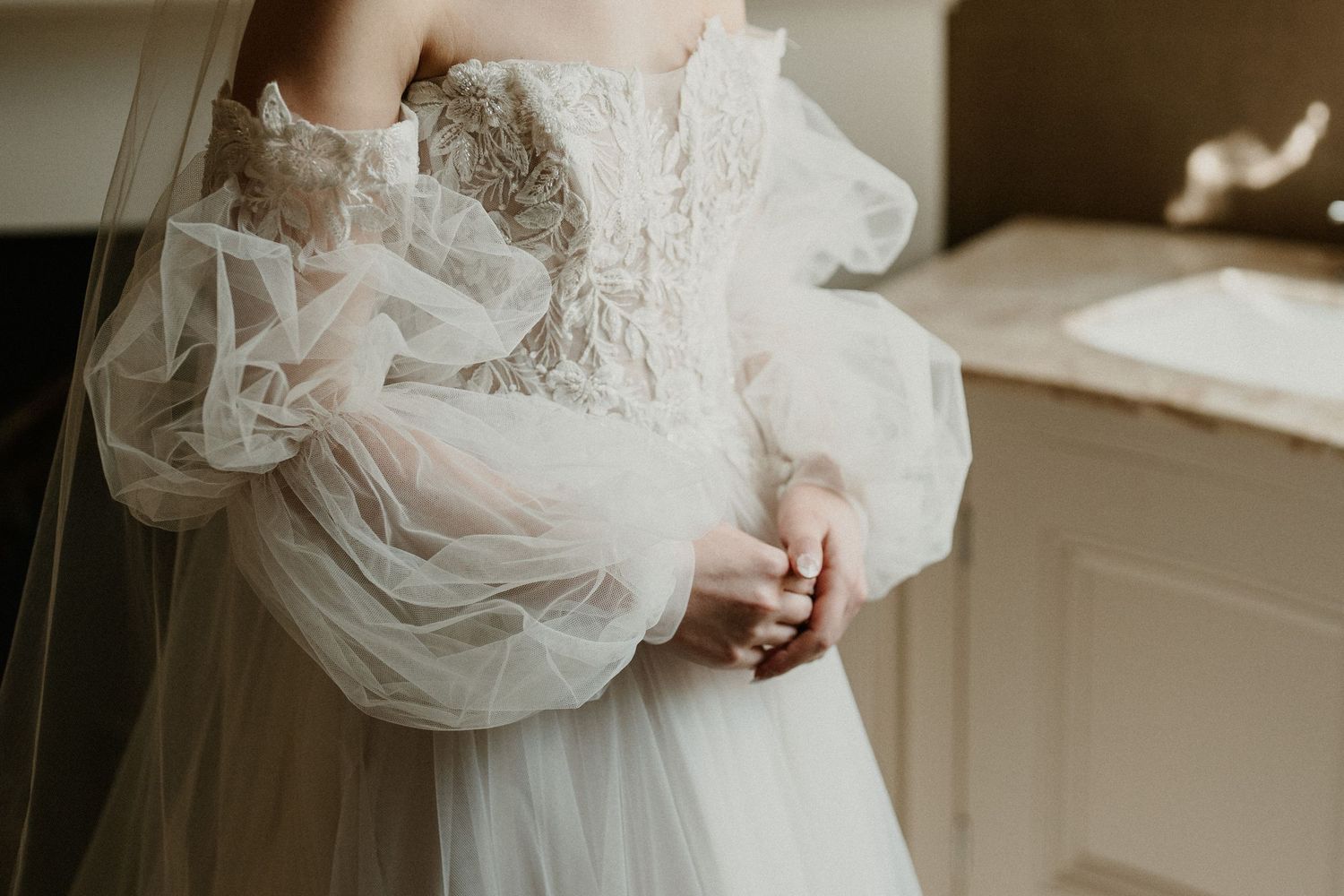Detail shots of a bride's wedding dress with delicate lace and tulle.