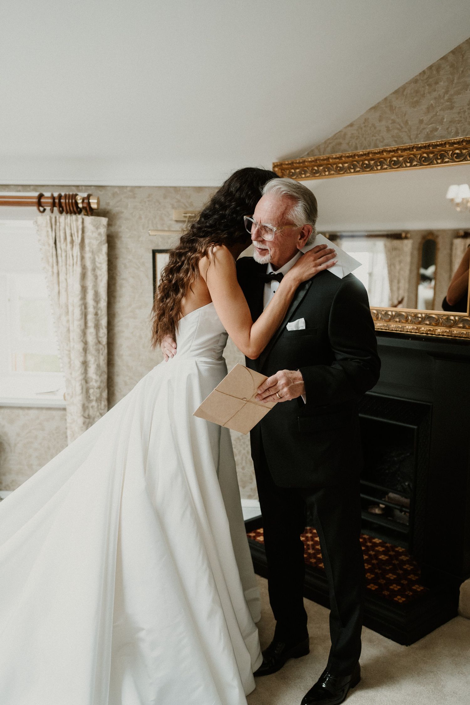 Dancing couple in formal attire spinning in an elegant room with gold-framed mirror.