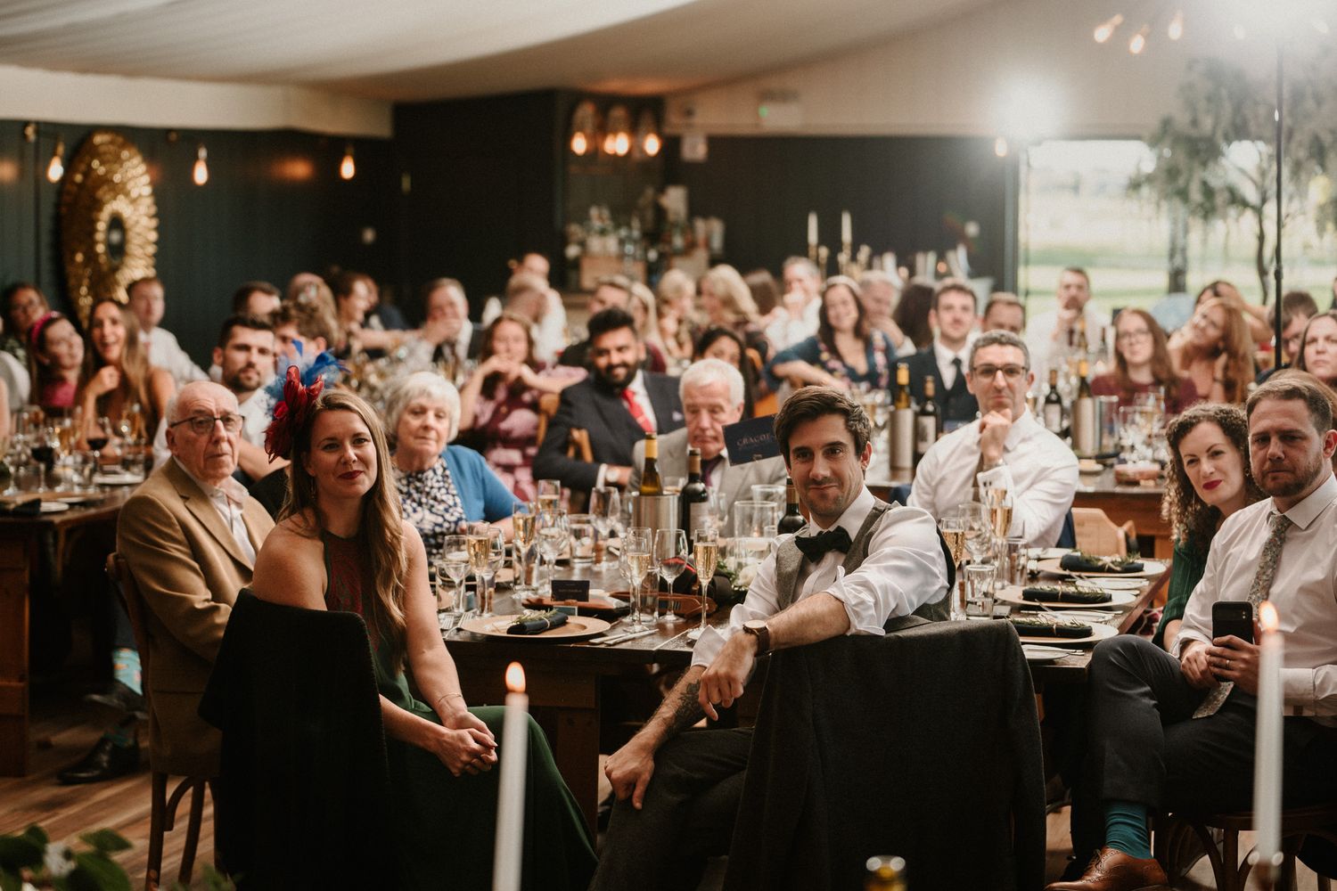 Large wedding reception hall filled with guests at decorated dining tables.
