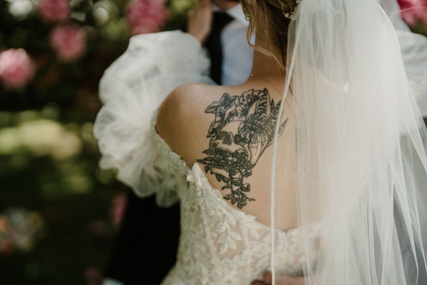Close-up detail of lace wedding dress and veil with delicate embellishments.