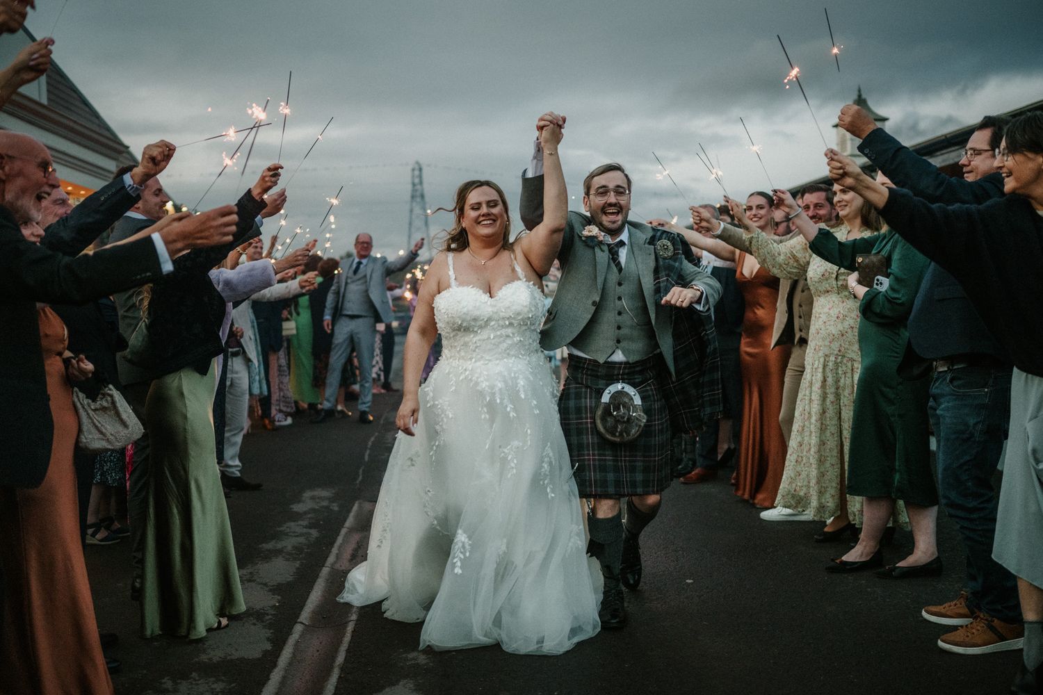 Wedding party walks through confetti shower during outdoor celebration exit.
