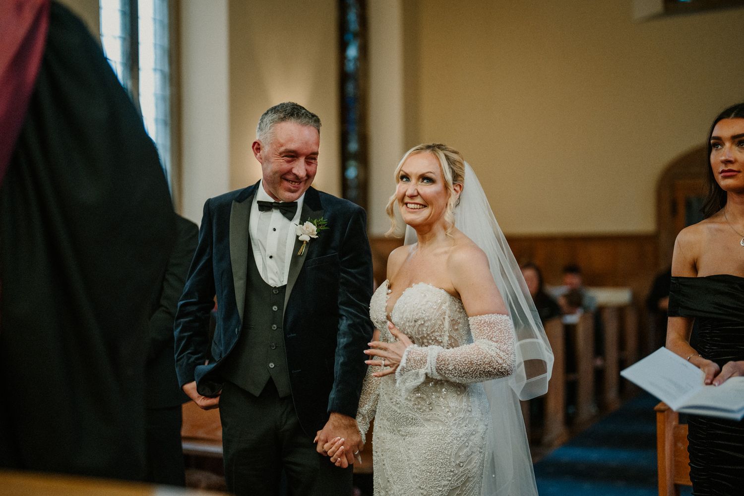 Intimate indoor wedding ceremony with guests gathered in a church sanctuary.