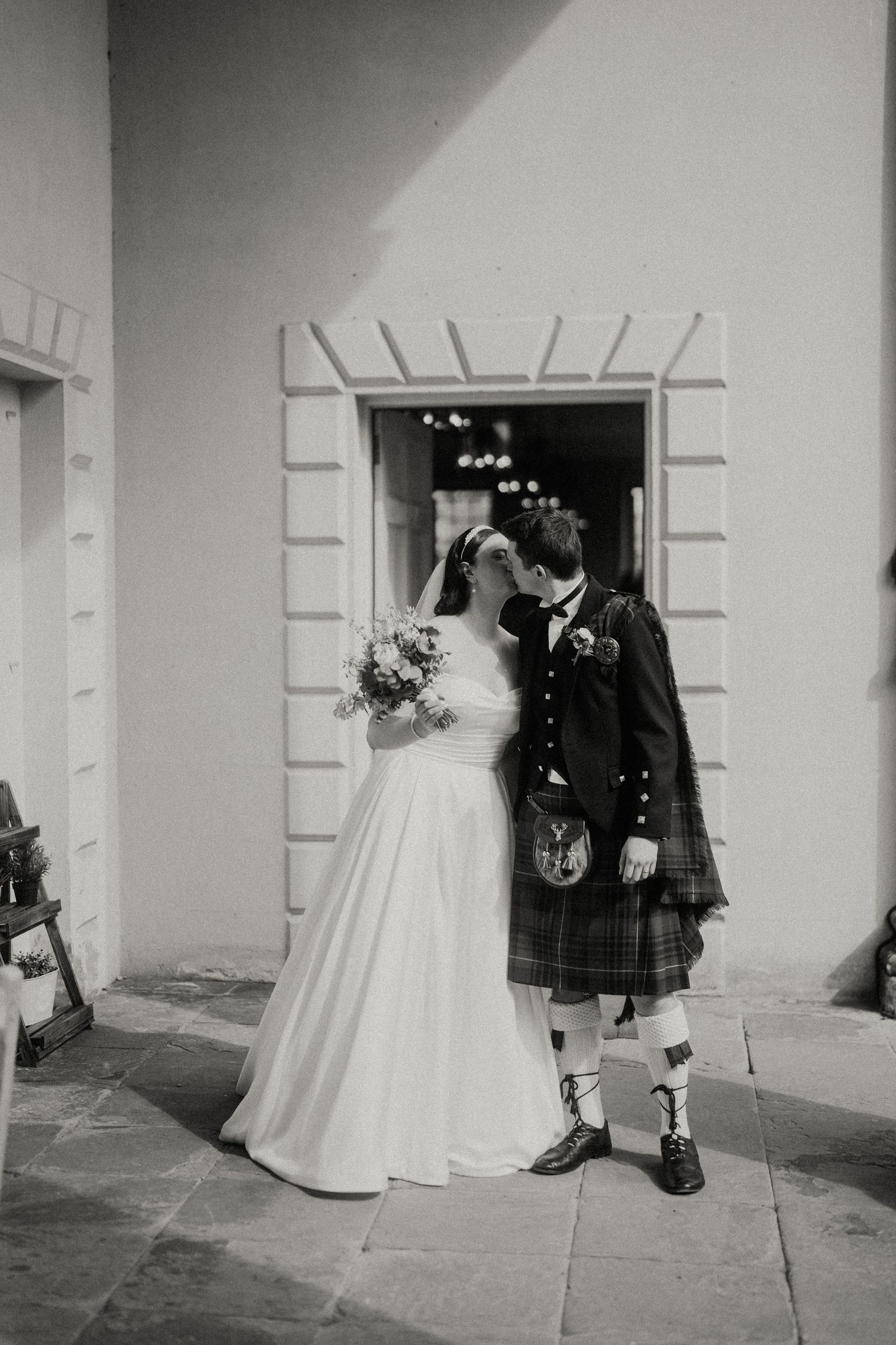 Black and white portrait of a wedding couple in Scottish formal wear.