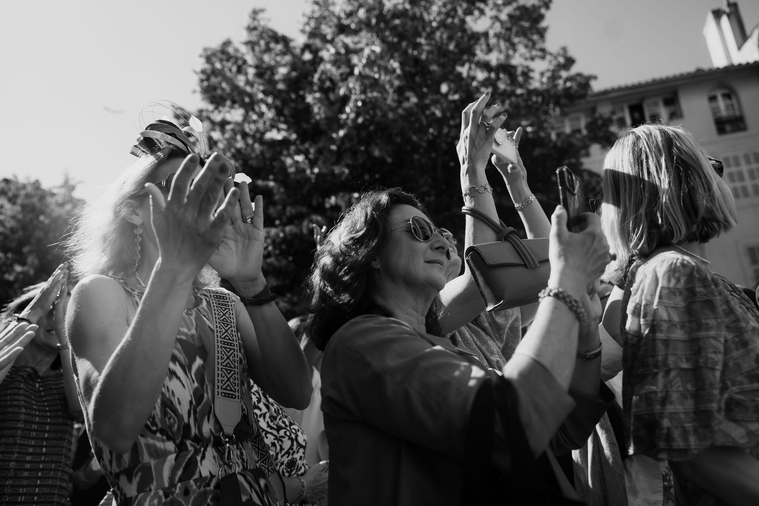 Black and white shots of celebration guests raising drinks in a toast sequence.