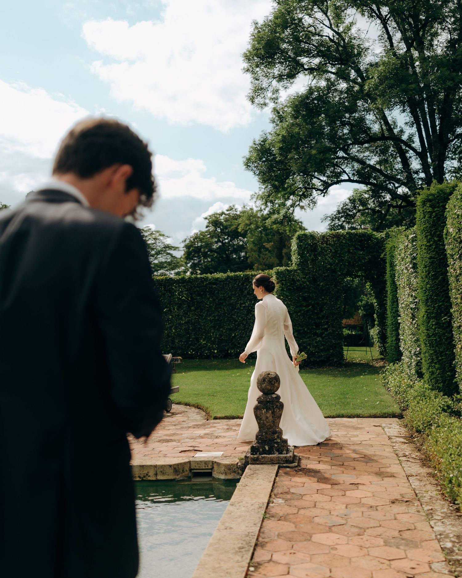 Garden pathway lined with manicured hedges and stone pavers.