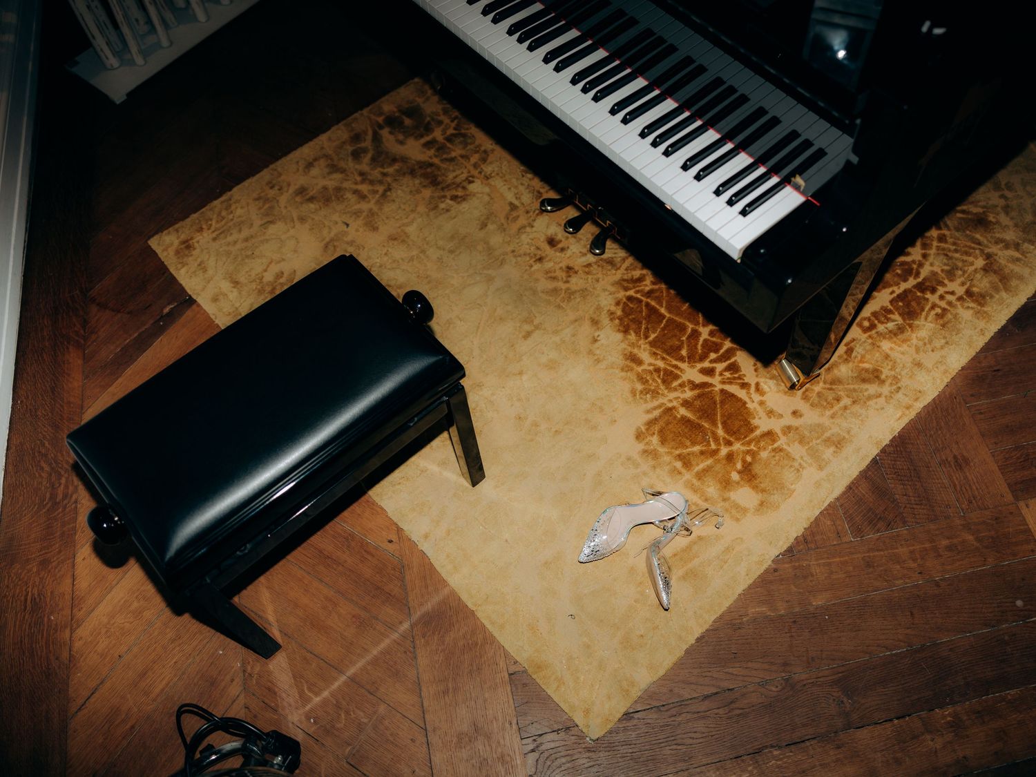 A close-up view of piano keys and sheet music on a wooden surface in warm lighting.