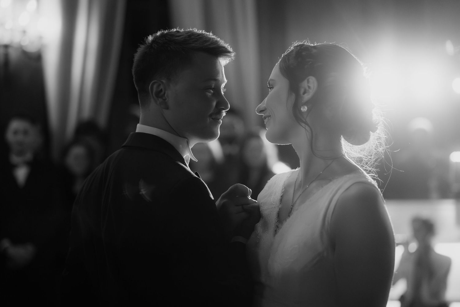 Intimate black and white portrait of wedding couple in dramatic lighting.