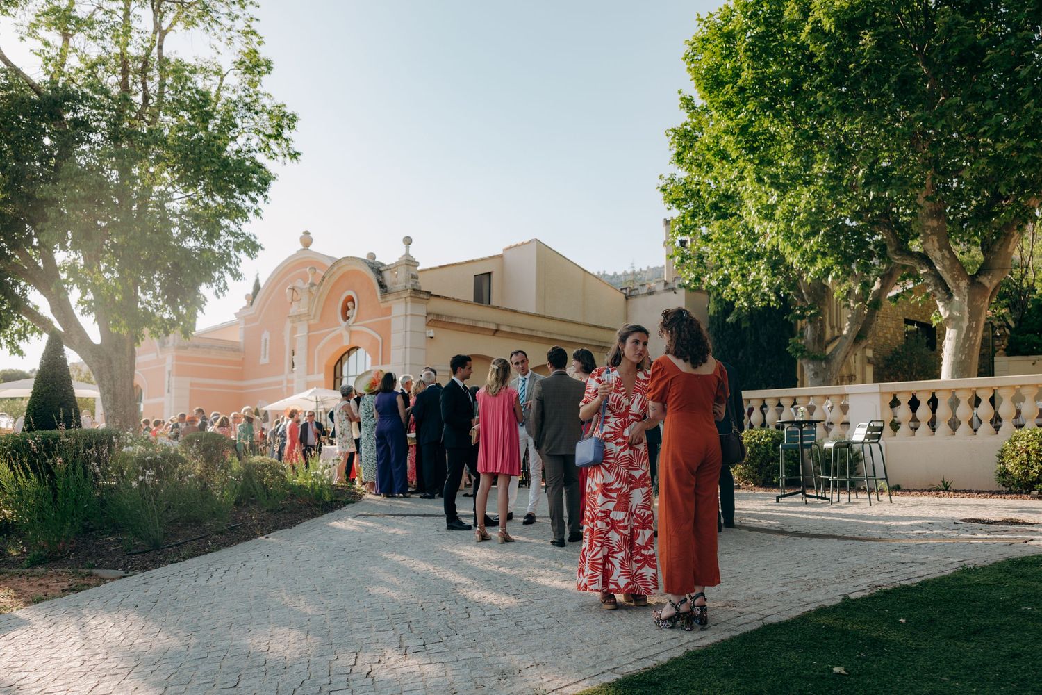 Panoramic view of a historic venue with guests gathered on a sunny afternoon.