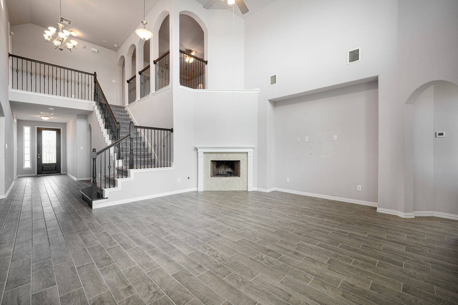 Open concept large living area with grey wood-look flooring and white walls home for sale Rosharon Texas.