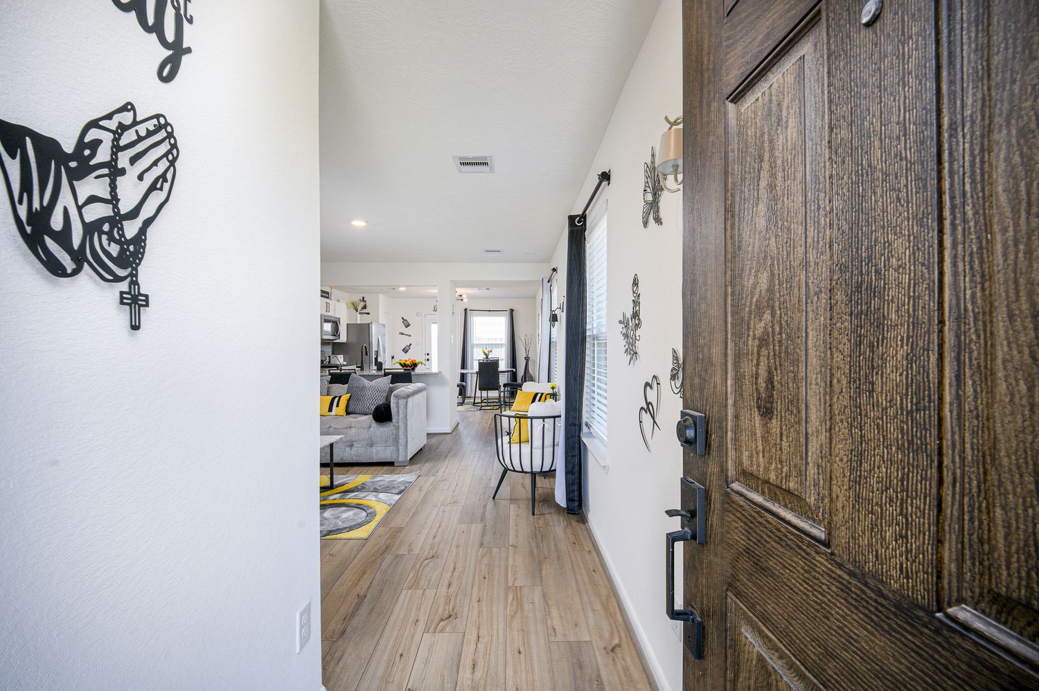 Hallway with wood panel walls and decorative wall art featuring modern lighting fixtures at 7316 Stella marina way in Texas city Texas.