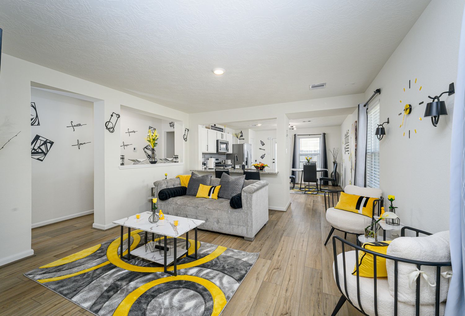 Modern office space with yellow accents, wood flooring, and white walls in an open layout.