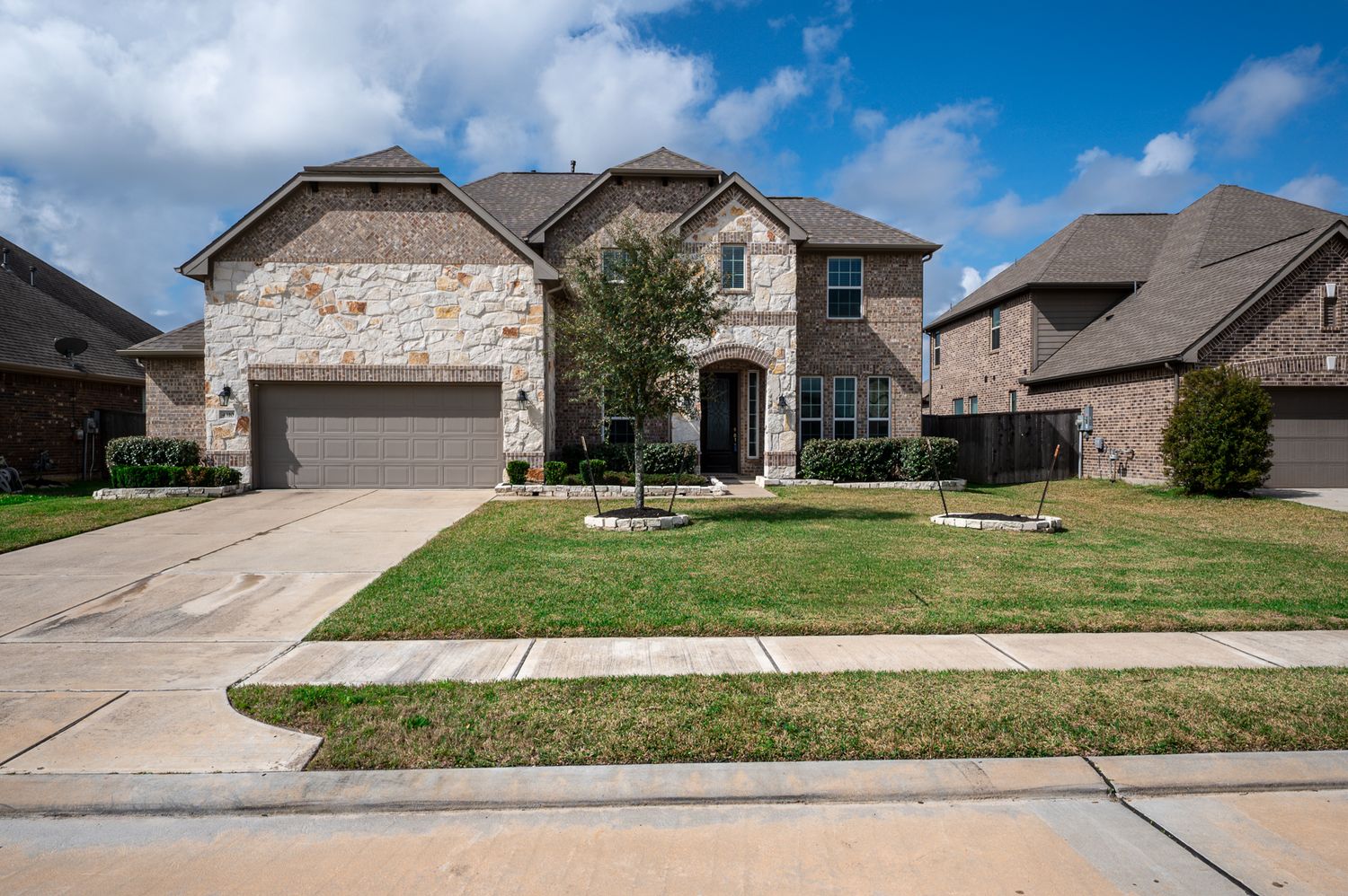 Row of modern brick homes with manicured lawns under blue sky at 4310 mark stone ridge lane Rosharon Texas