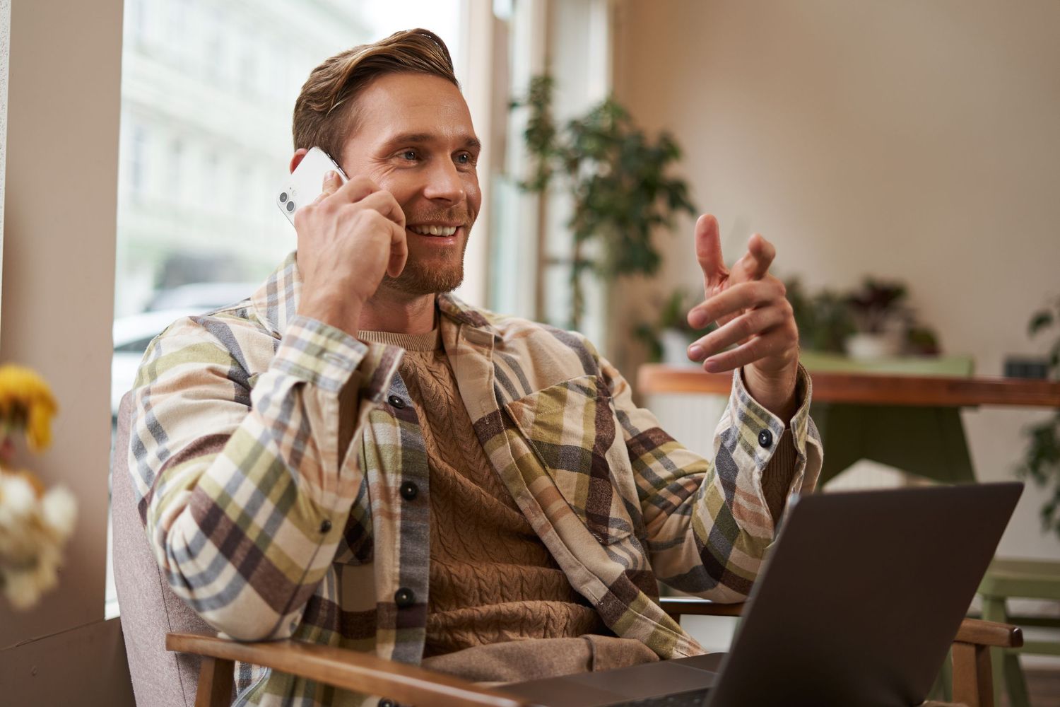 Man talking on the phone in a café, symbolizing everyday life stability and reaching out for support.