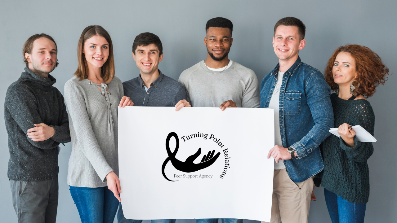 Group of people holding a sign with the Turning Point Relations business name, symbolizing unity, community support, and shared purpose.