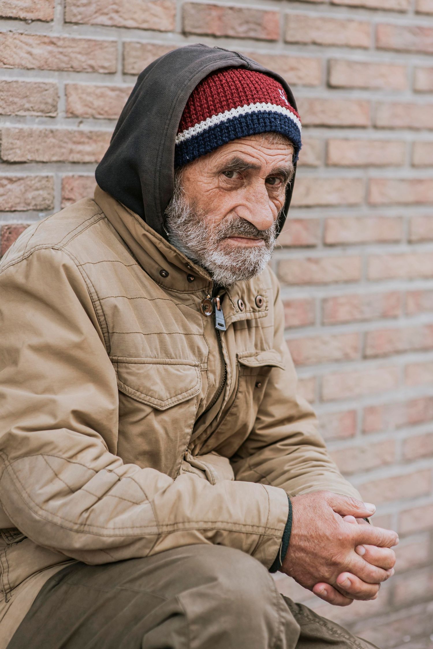 Man sitting outdoors alone, reflecting the challenges many adults face before seeking recovery and peer support.