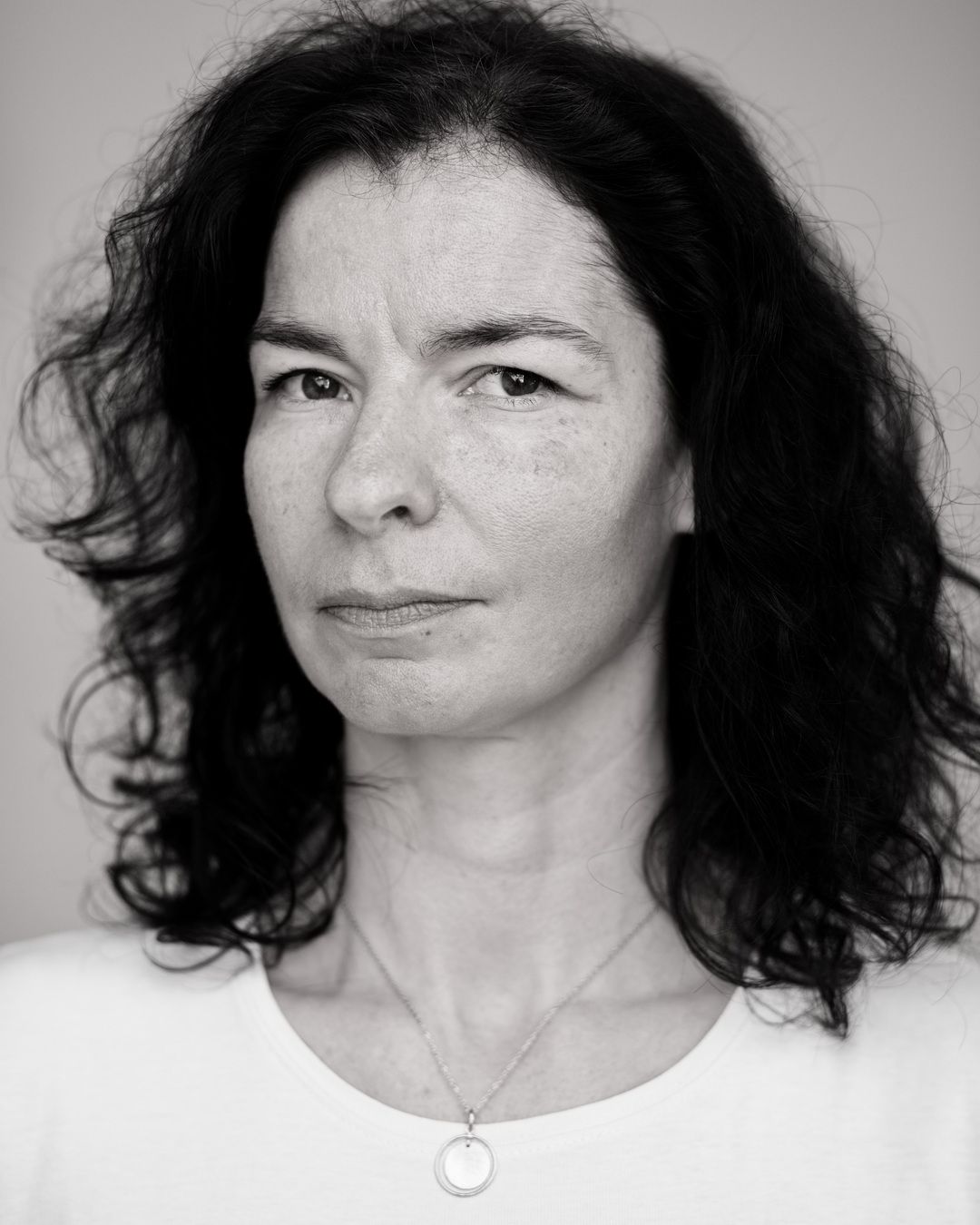 Schwarz/weiß Portrait einer Frau mittleren Alters mit einem ausdrucksvollen Blick in die Kamera