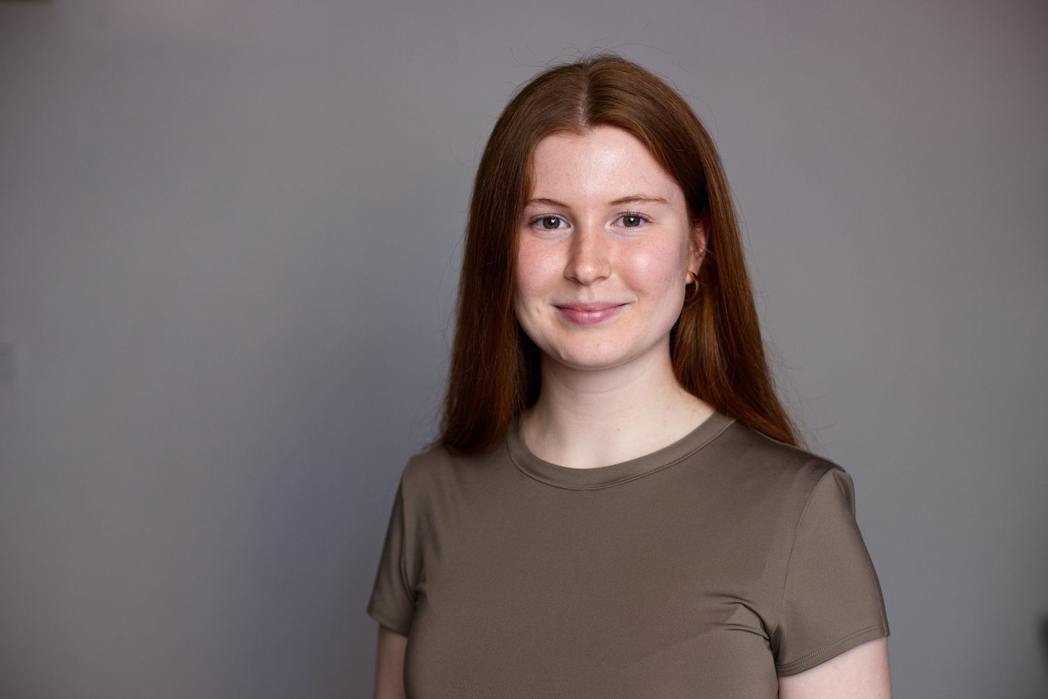 Portrait einer jungen Frau mit rötlichen Haaren in einem oliv-farbenen T-Shirt, passend zu ihrer Bewerbung als Landschaftsarchitektin