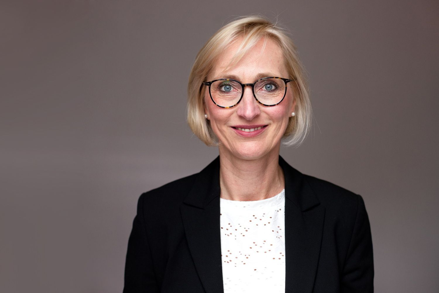 Professionelles Businessportrait einer Frau mittleren Alters mit einer Brille
