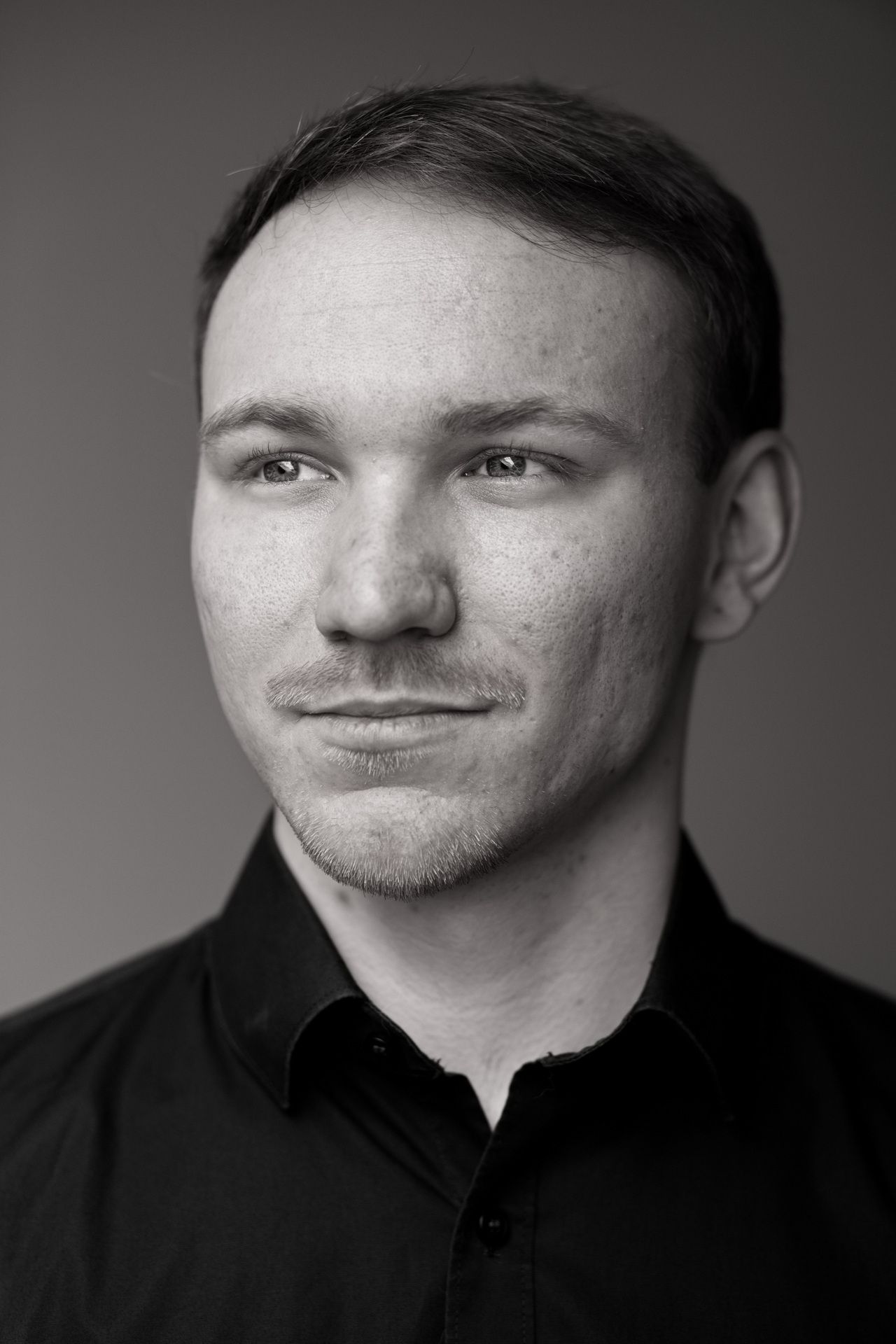 Schwarz/weiß Portrait eines jungen Mannes, der zur Seite blickt