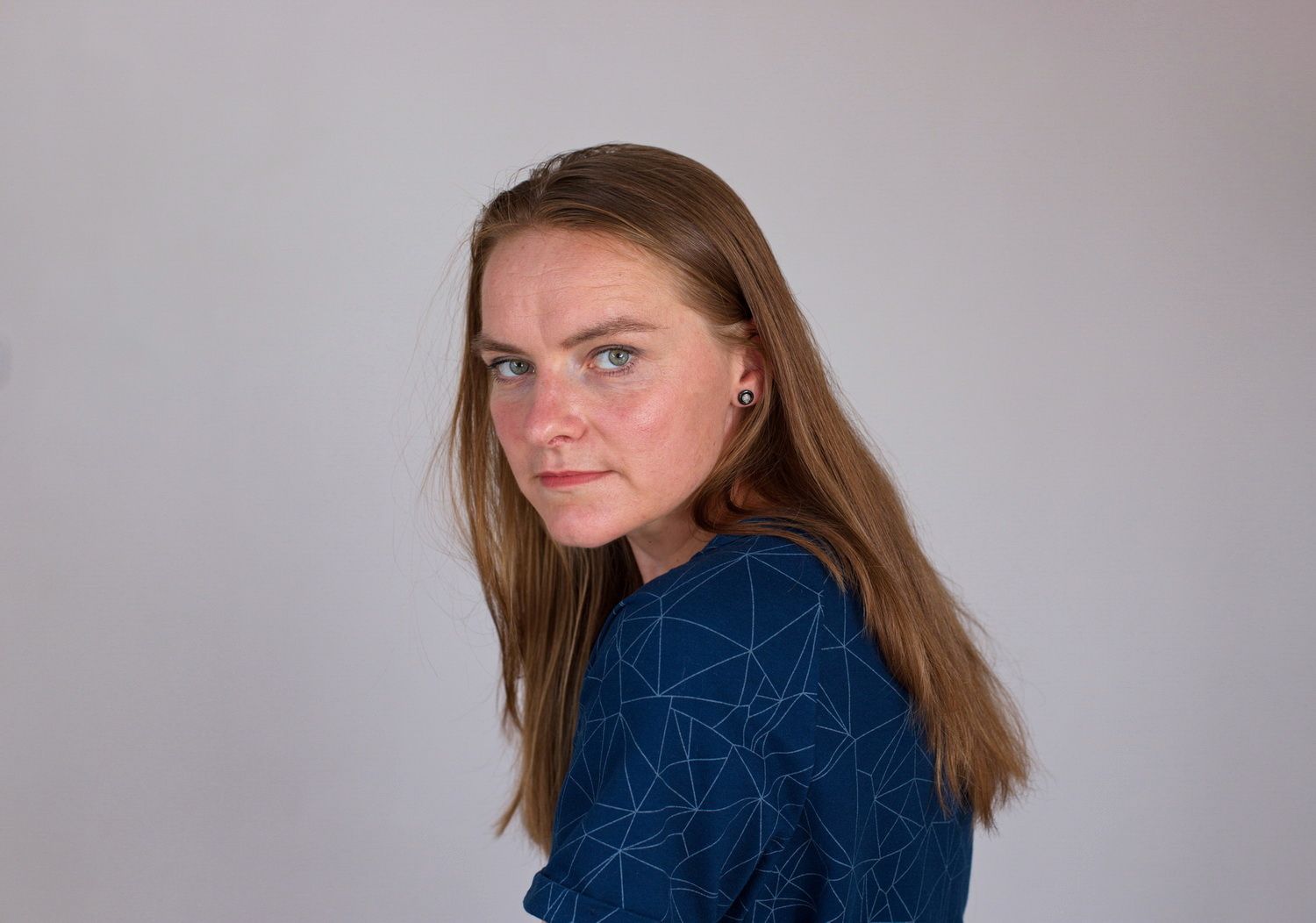 Selbstportrait der Fotografin mit offenem Haar und einem neutralen Blick in die die Kamera