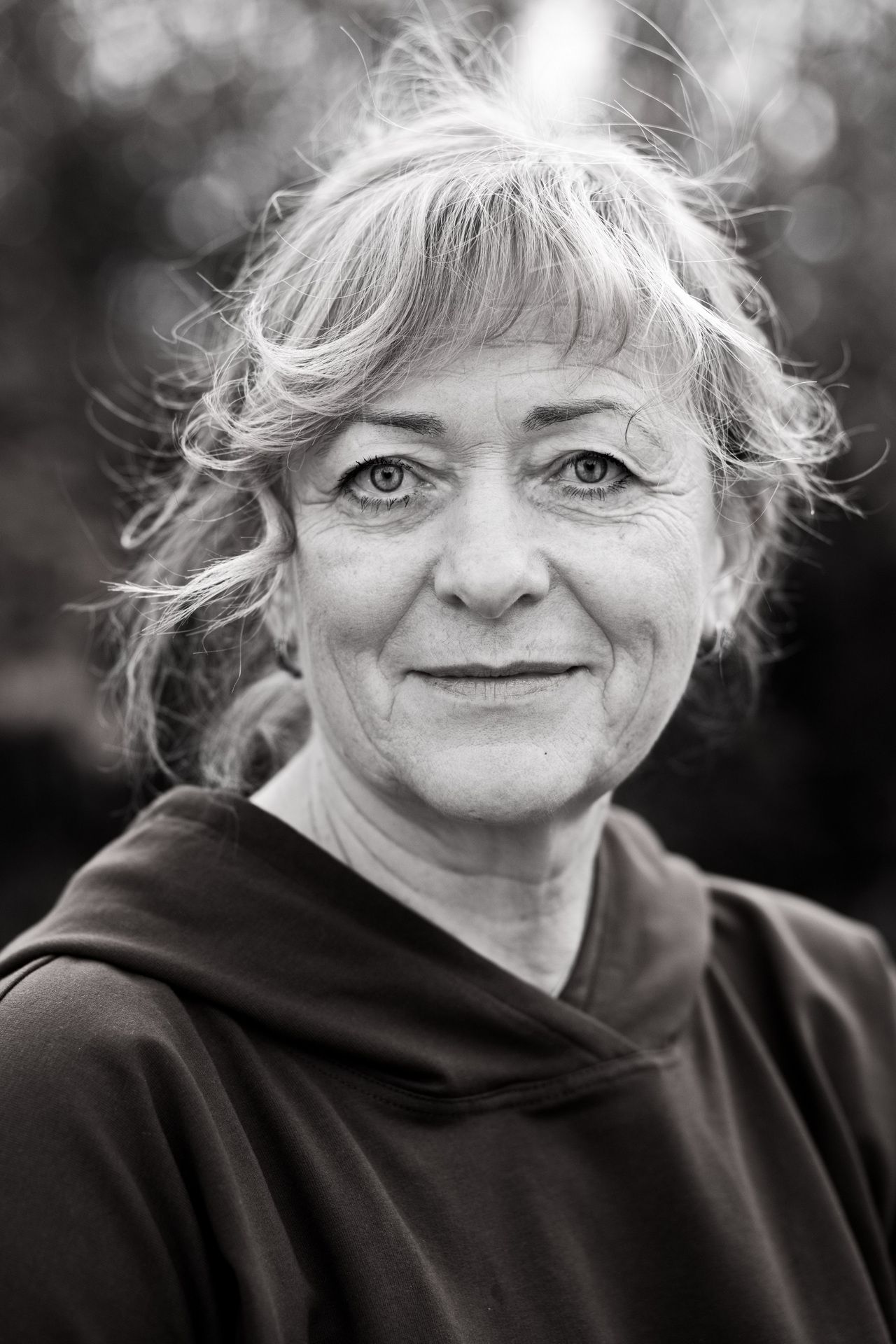 ausdrucksstarkes Portrait einer Frau in schwarz/weiß mit einem leichten Lächeln