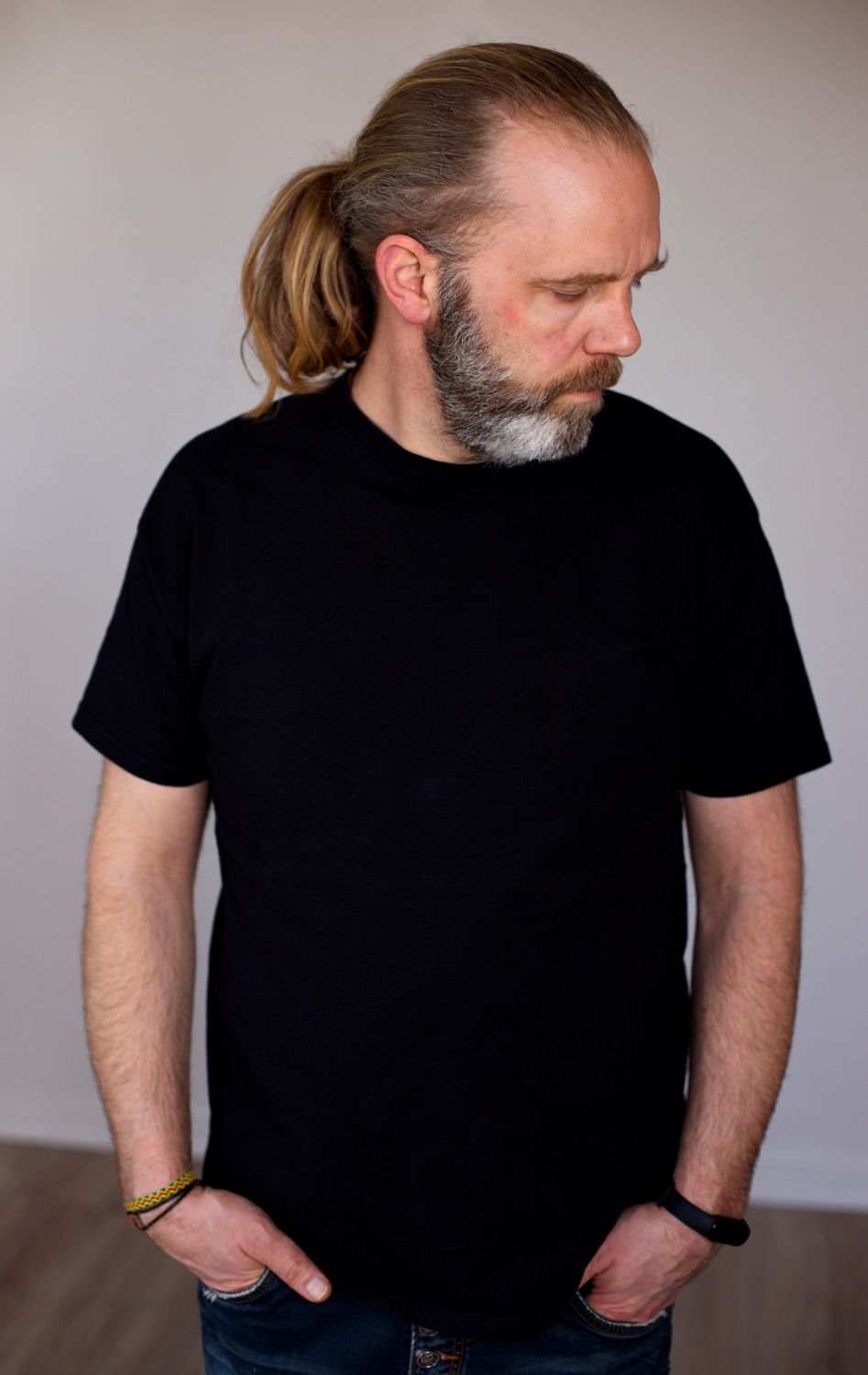 Portrait eines Mannes mittleren alters mit langengen Haaren. Er schaut schräg nach unten.