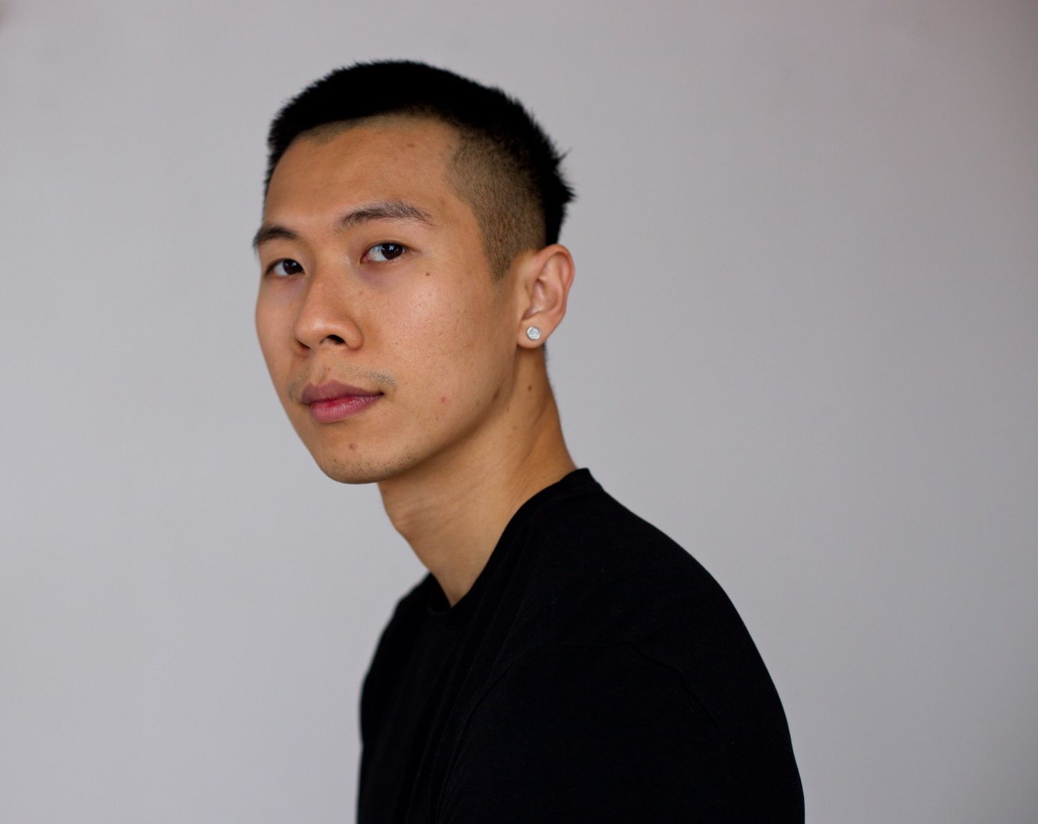 Portrait eines jungen asiatischen Mannes mit einem neutralen aber ausdrucksstarken Blick in die Kamera