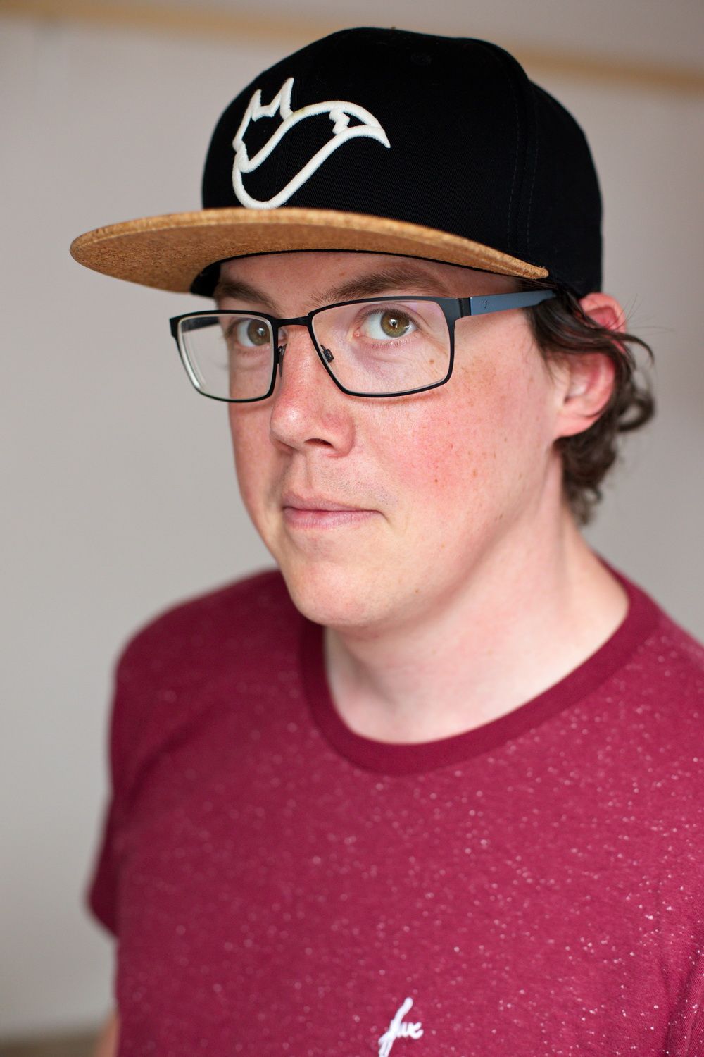 Portrait eines jungen Mannes mit einem neutralen aber offenem Ausdruck und Blick in die Kamera