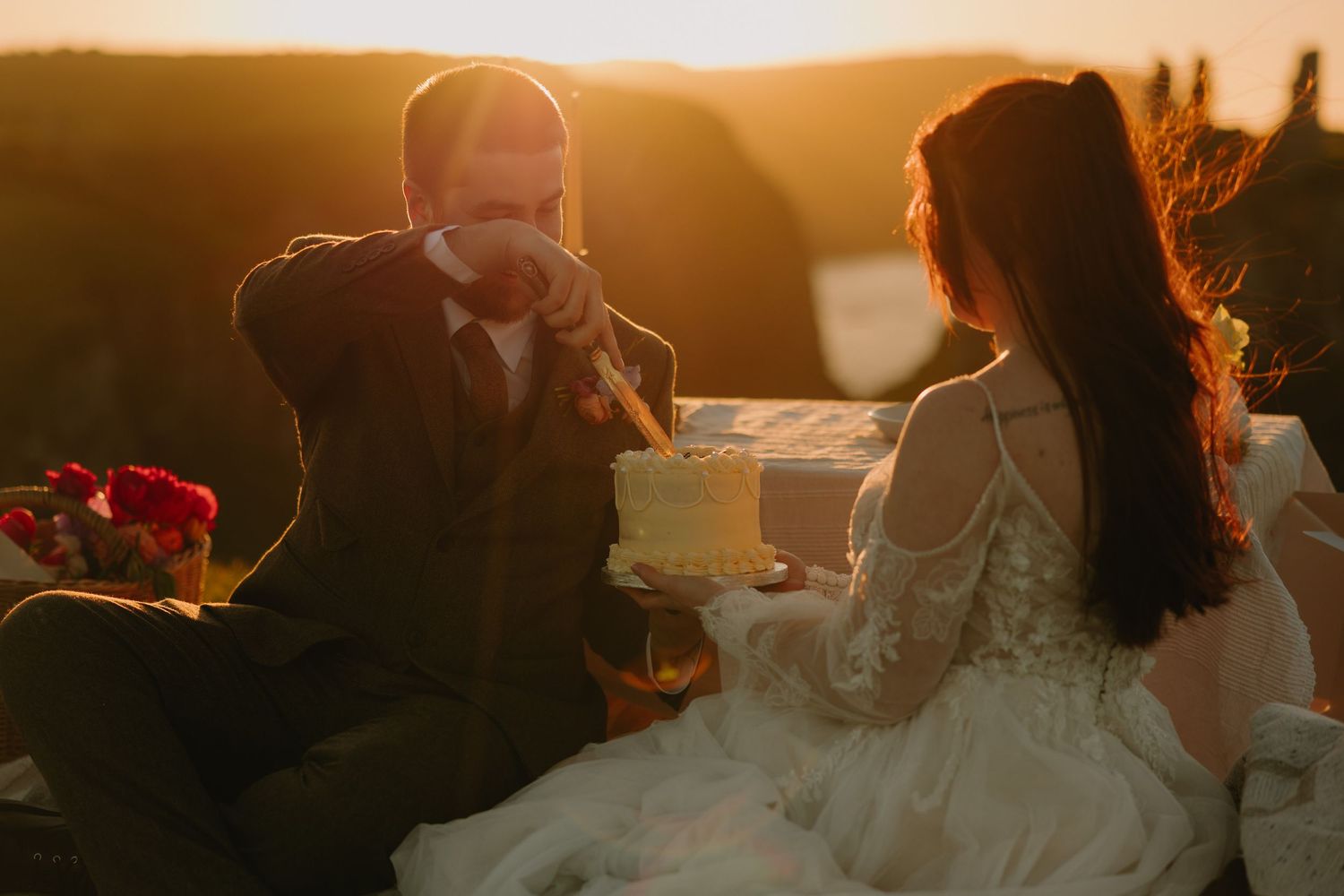 Golden sunset lighting illuminates an outdoor wedding reception setting.