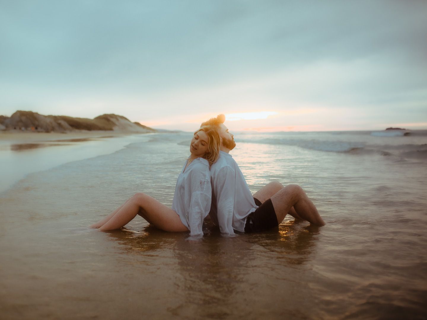 Couple on the beach during sunset engagement photoshoot