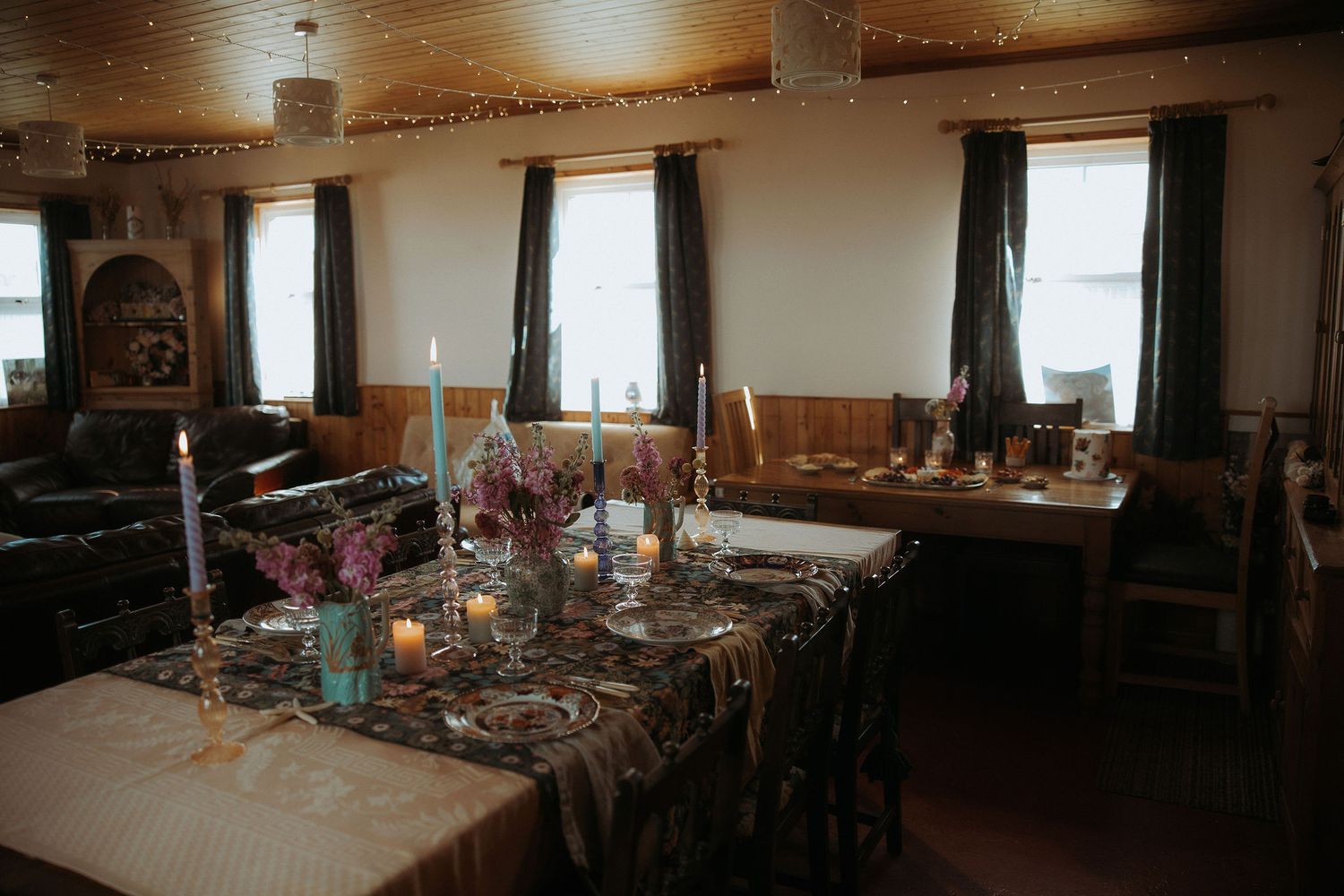 A rustic barn interior with wooden beams and sunlight streaming through windows creates a warm, atmospheric setting.