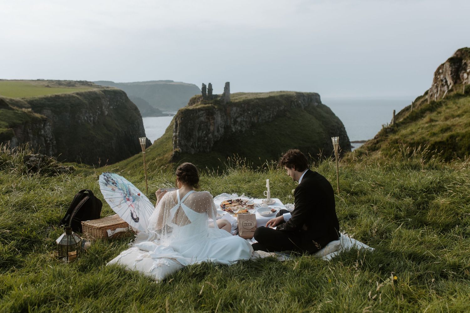 A picnic scene set on dramatic coastal cliffs overlooking the ocean.