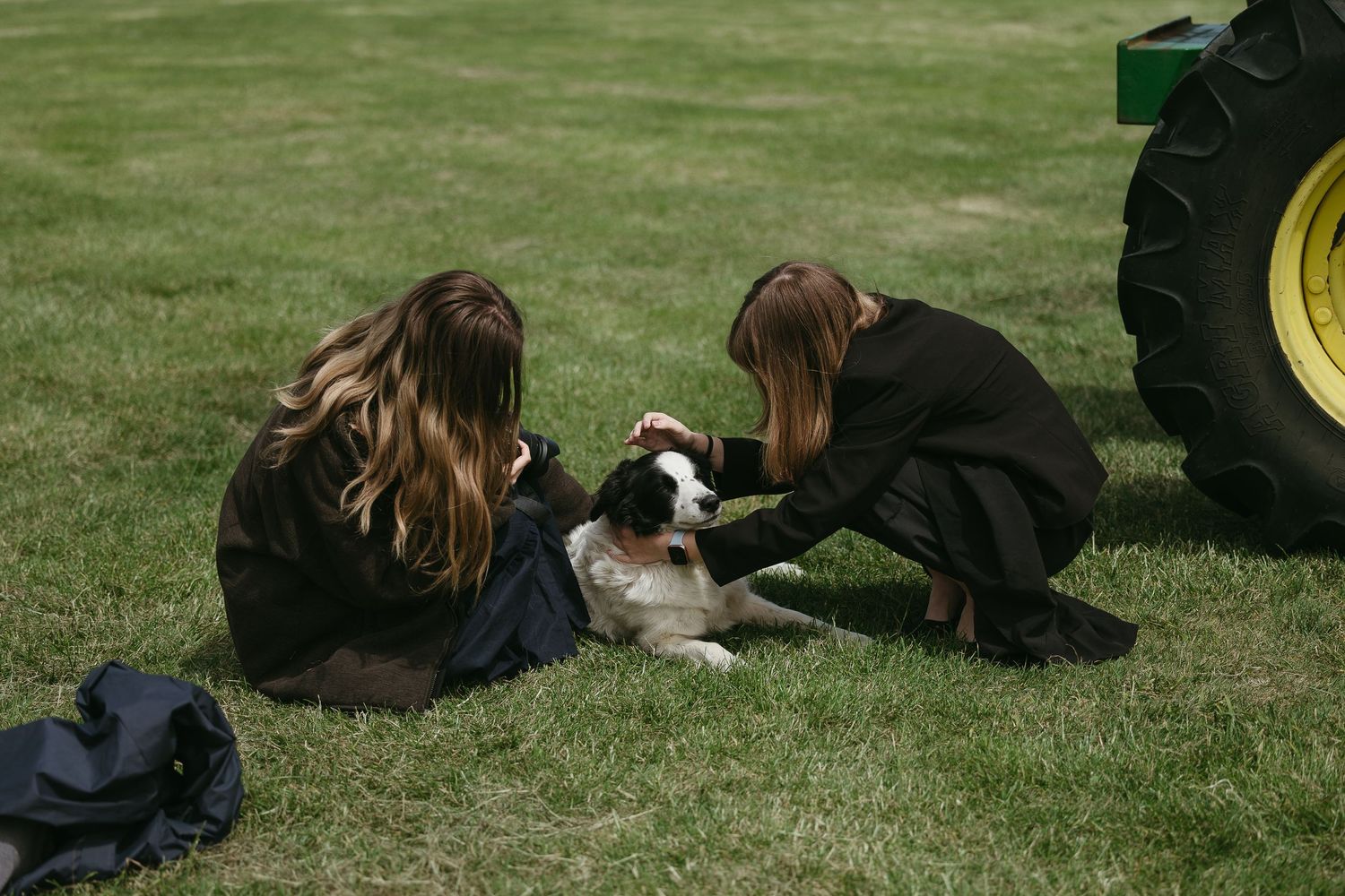 Students lying on grass in a row during an outdoor activity at a school or university.