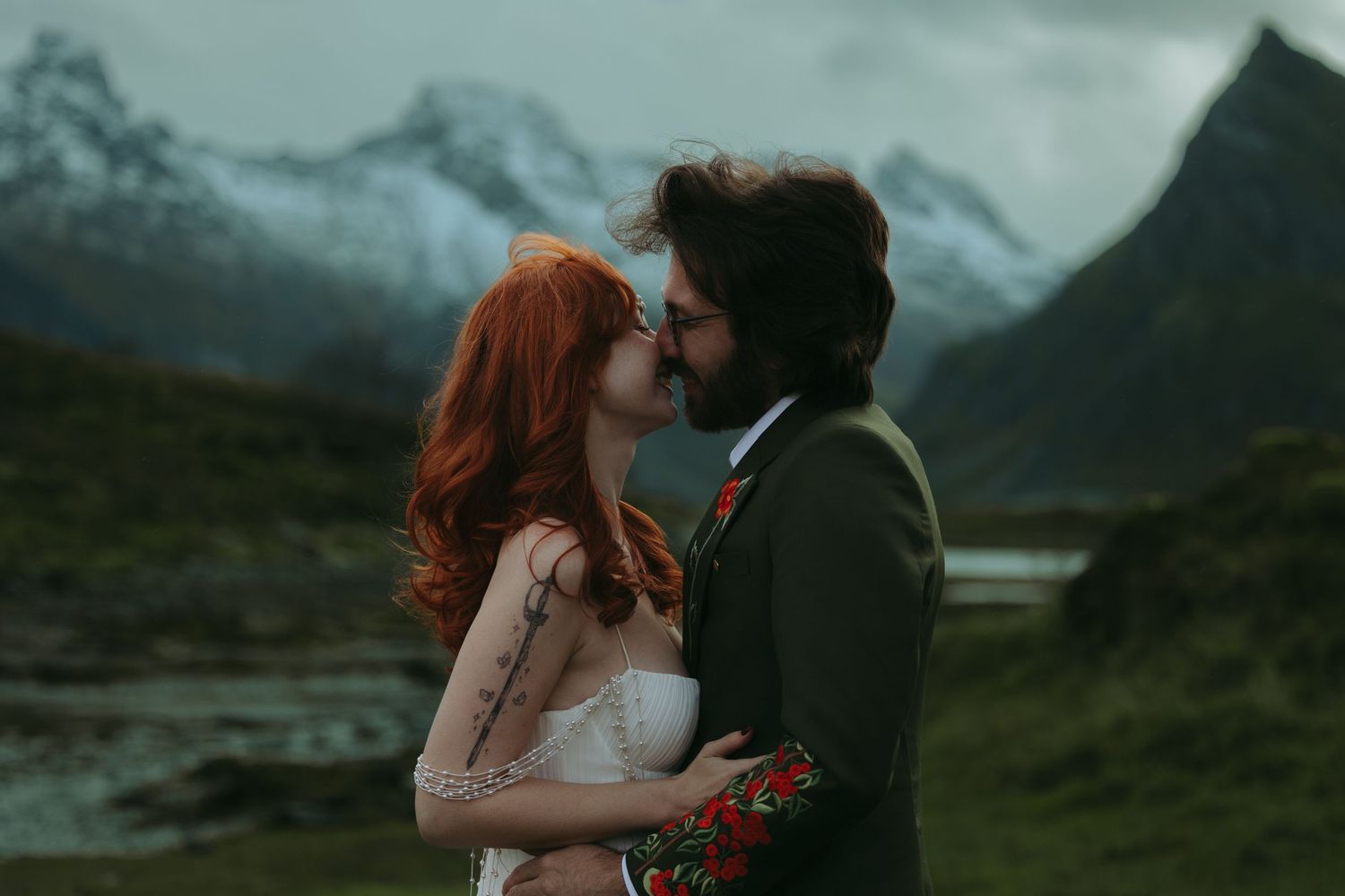 Romantic outdoor photoshoot against misty mountain backdrop in moody lighting.