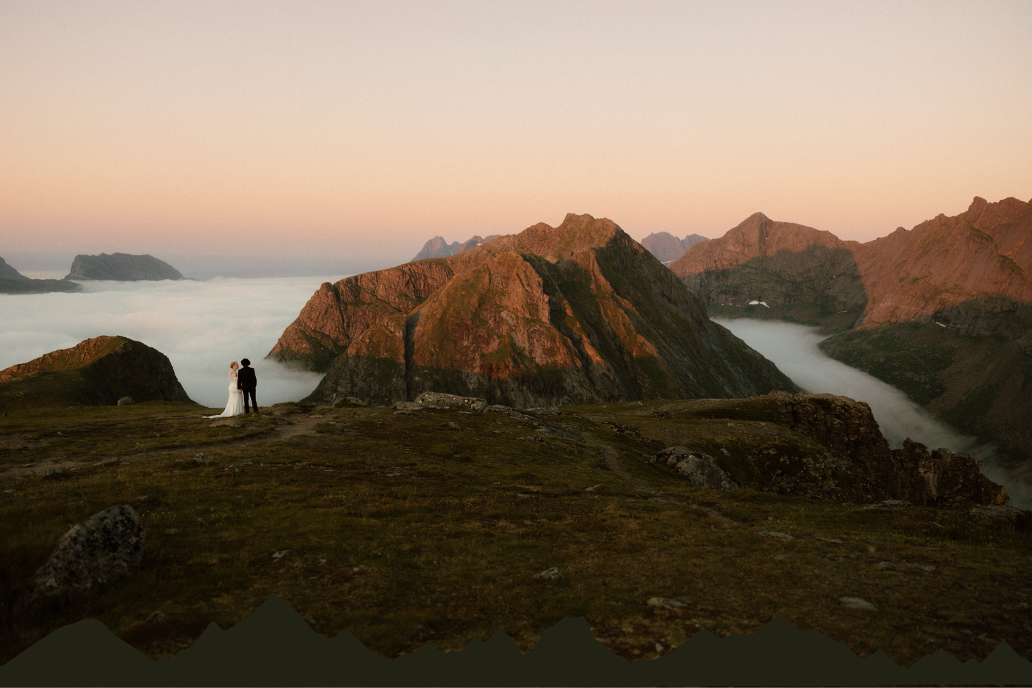 Mountainous coastline bathed in warm evening light with dramatic cliffs meeting the sea.