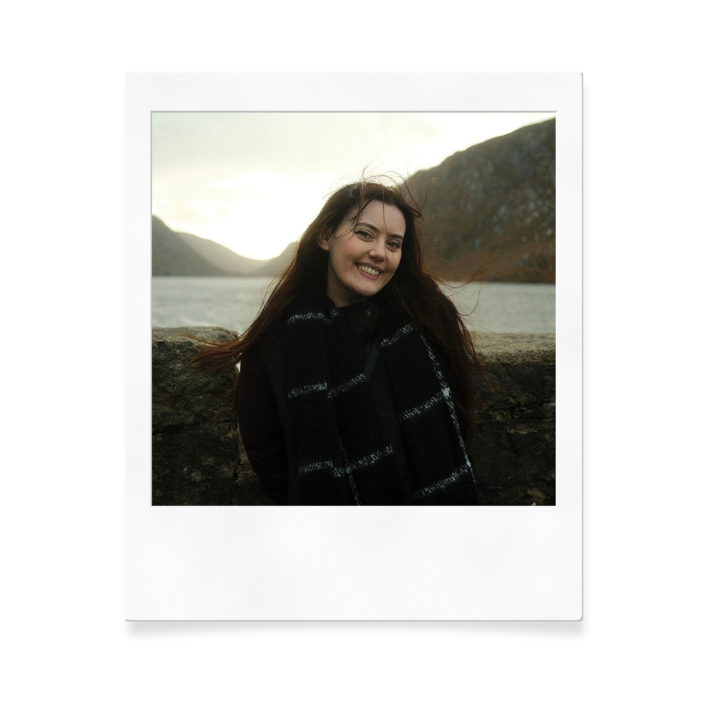 Polaroid-style portrait against a misty mountain lake backdrop.