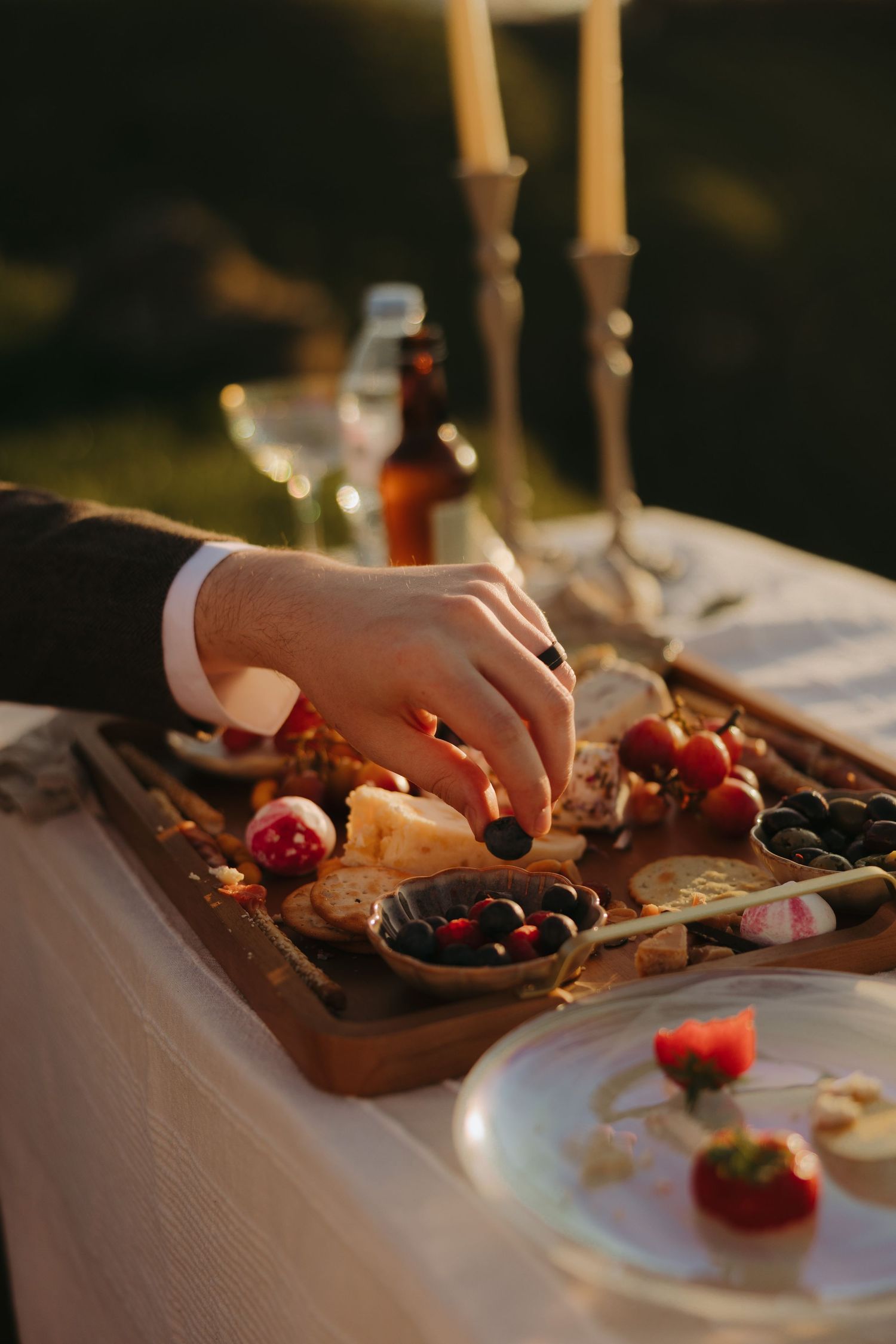 Wedding reception table with appetizers and cherries in warm evening light.