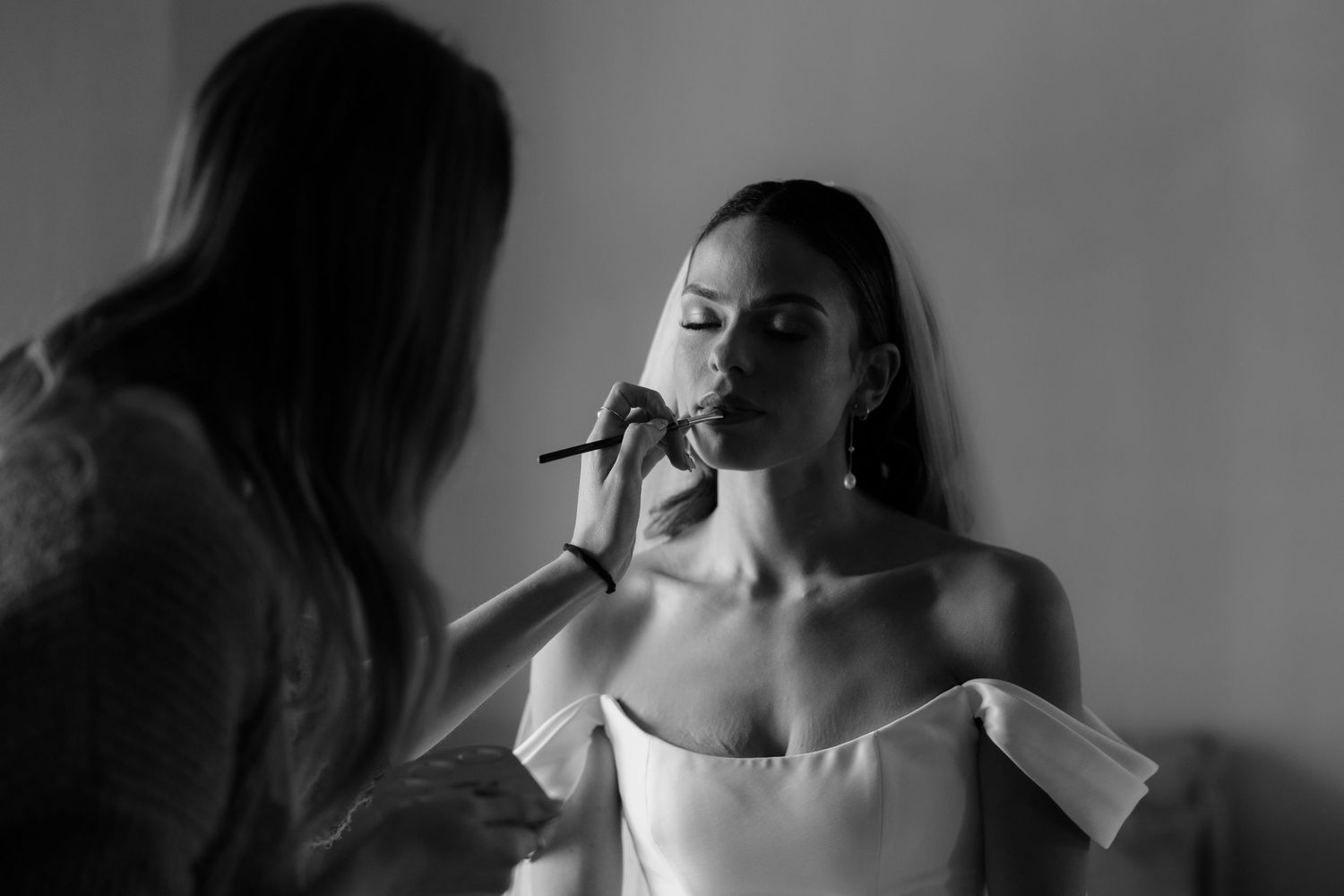 Black and white candid wedding preparation moments.