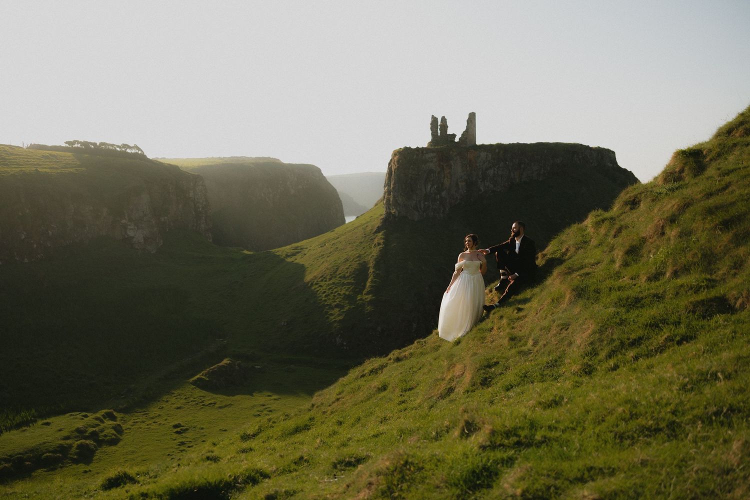 Dramatic coastal cliffs and grassy slopes against moody sky in Northern Ireland.
