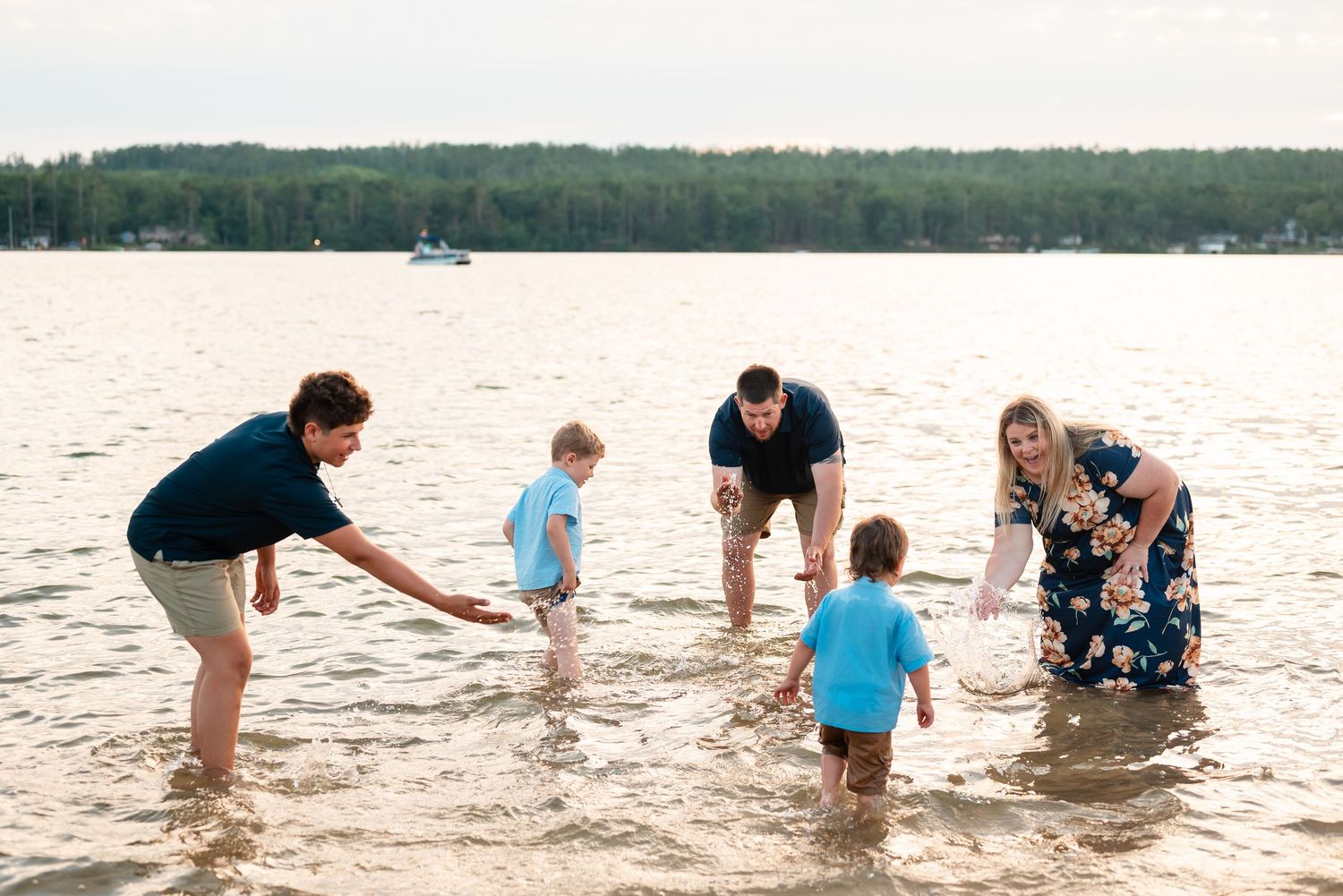 A family session in shallow water during beach photoshoot at sunset.