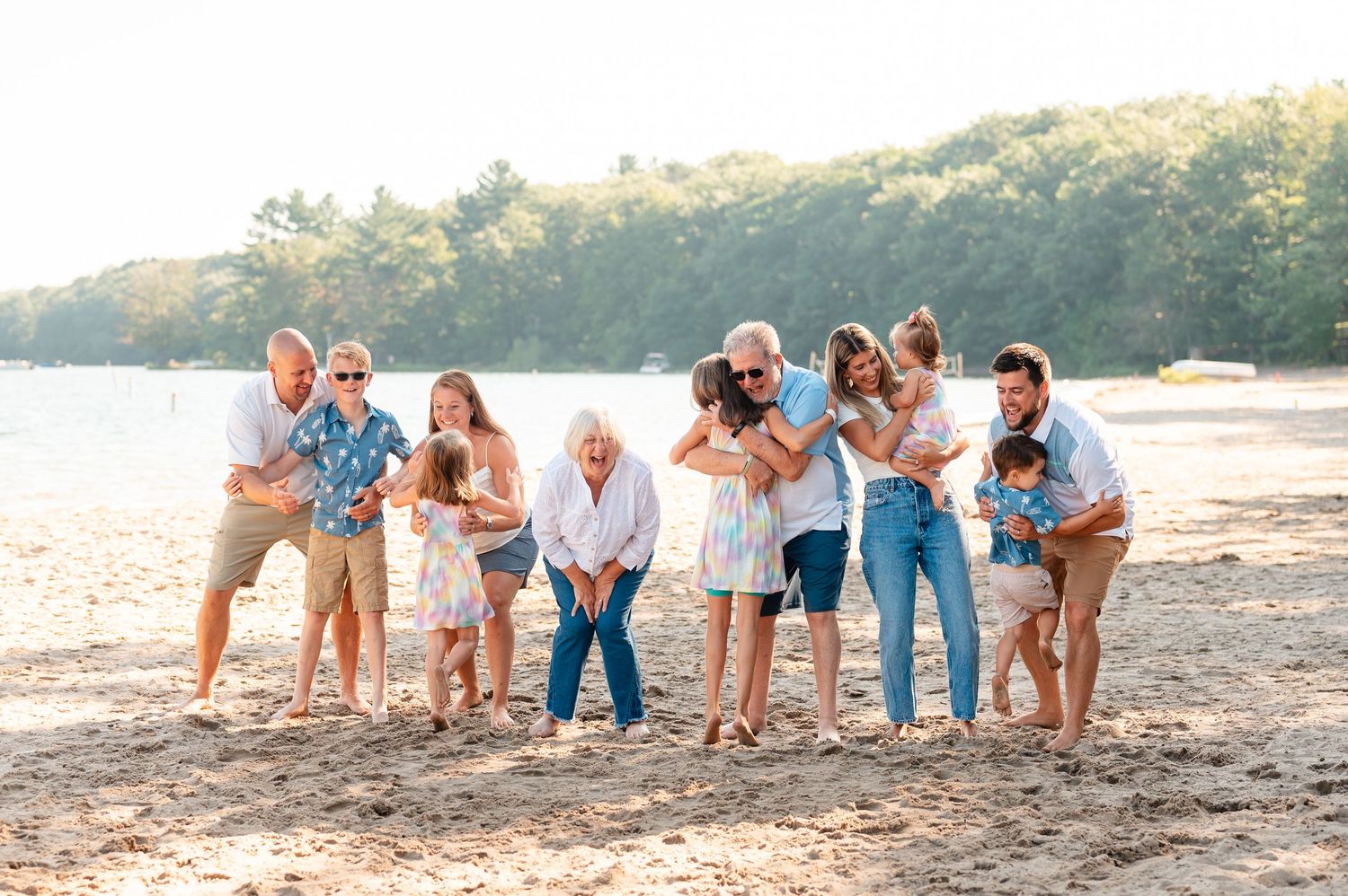 Family are hugging each other along at the lake in the morning.